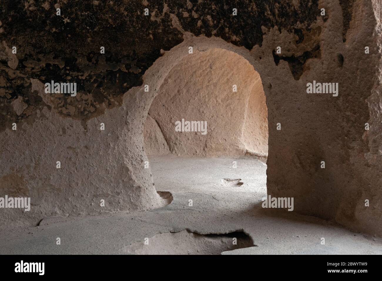 NM00459-00...NUOVO MESSICO - Antica dimora di roccia scavata dalla roccia morbida della scogliera sopra il Canyon di Frijoles dai Puebloans ancestrali a Bandelie Foto Stock
