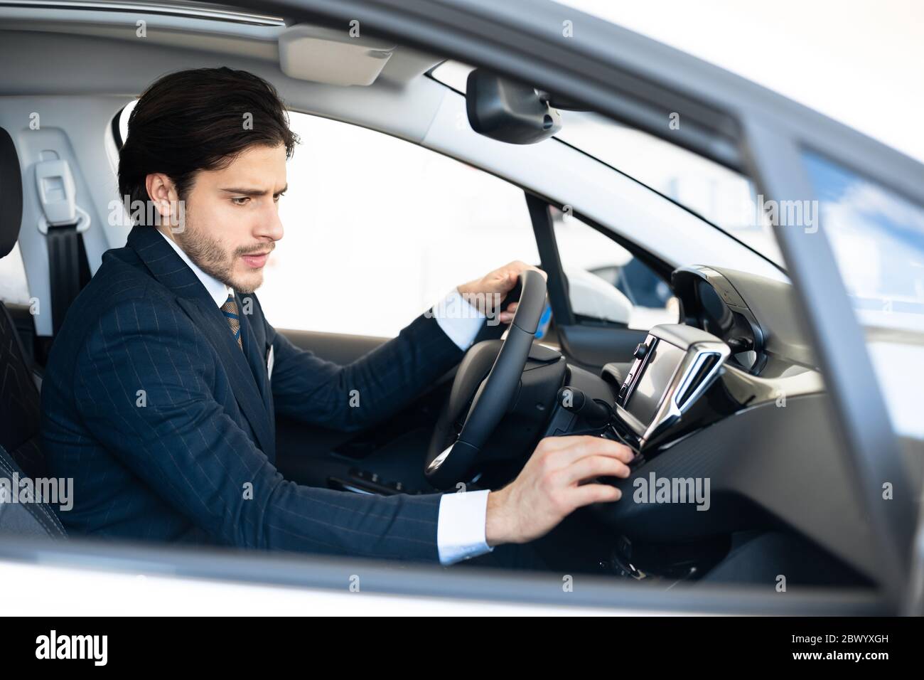 Venditore di auto professionale seduto in auto controllo Dashboard Foto Stock