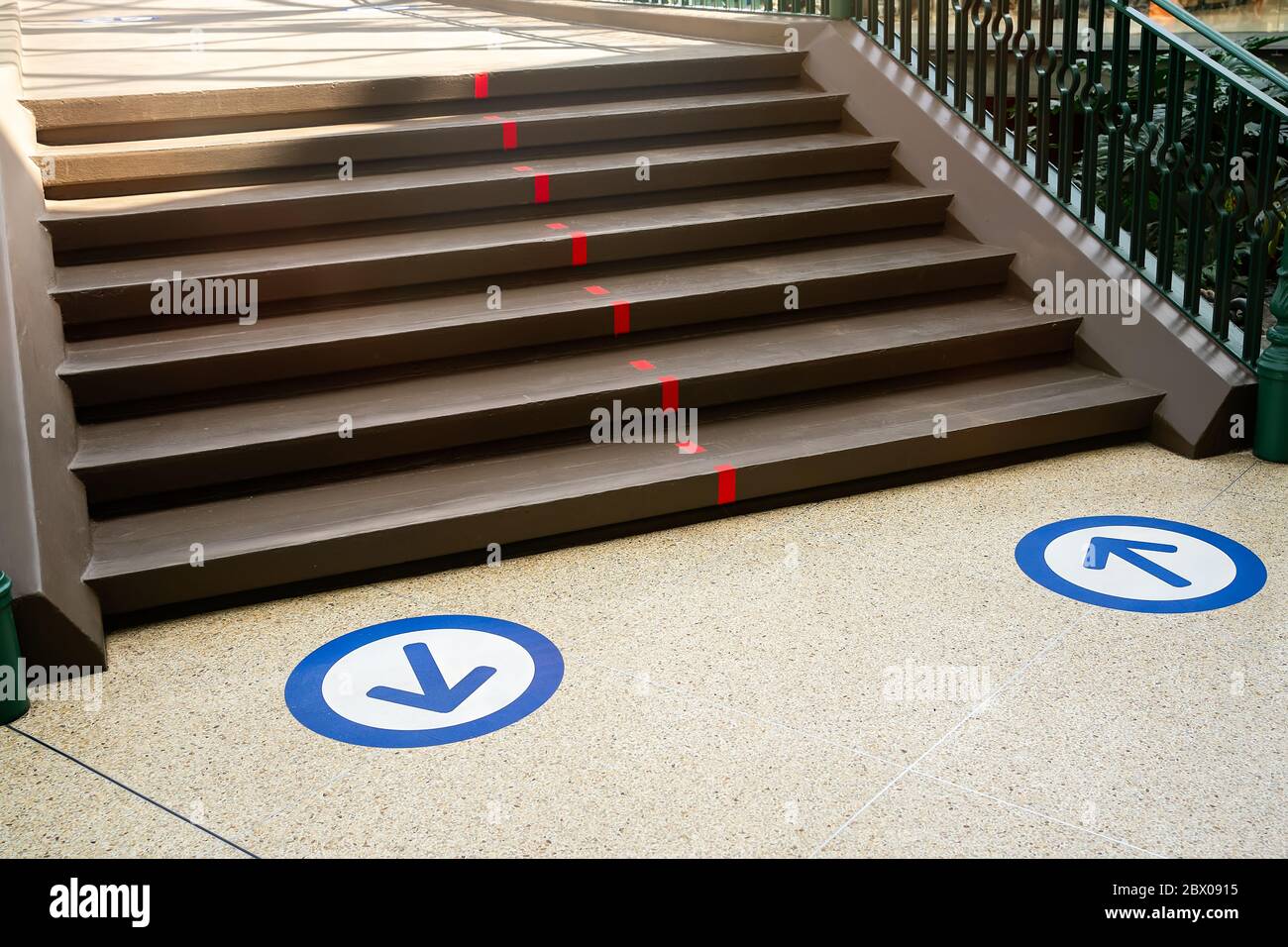 Misure di protezione epidemica in negozi, centri commerciali o centri commerciali pavimento blu adesivi cerchio con freccia . Shopping a distanza. Vita dopo il virus. Foto Stock