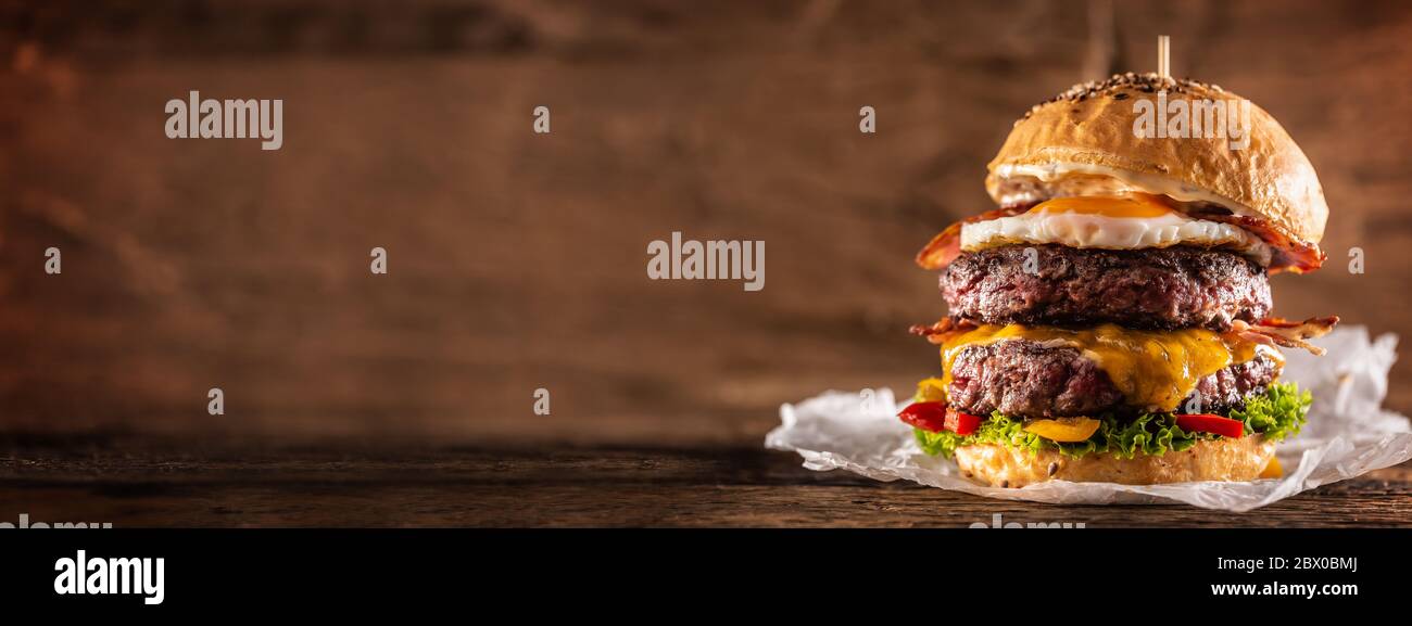 Hamburger di manzo doppio con formaggio, uova fritte, pancetta, insalata e peperoni Foto Stock