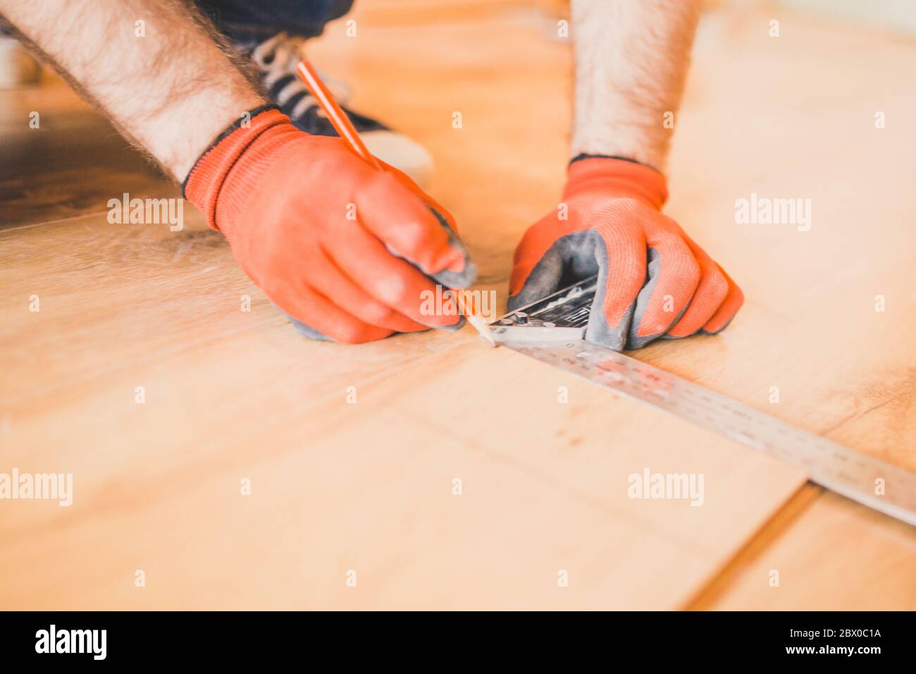 Man installazione nuovo pavimento in legno laminato - pavimento flottante Foto Stock