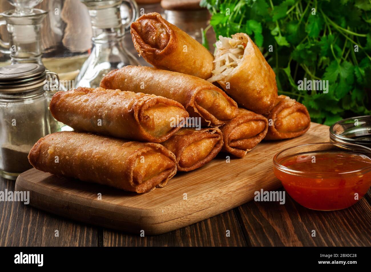 Involtini primavera con pollo e verdure sul tagliere. Cucina asiatica. Foto Stock