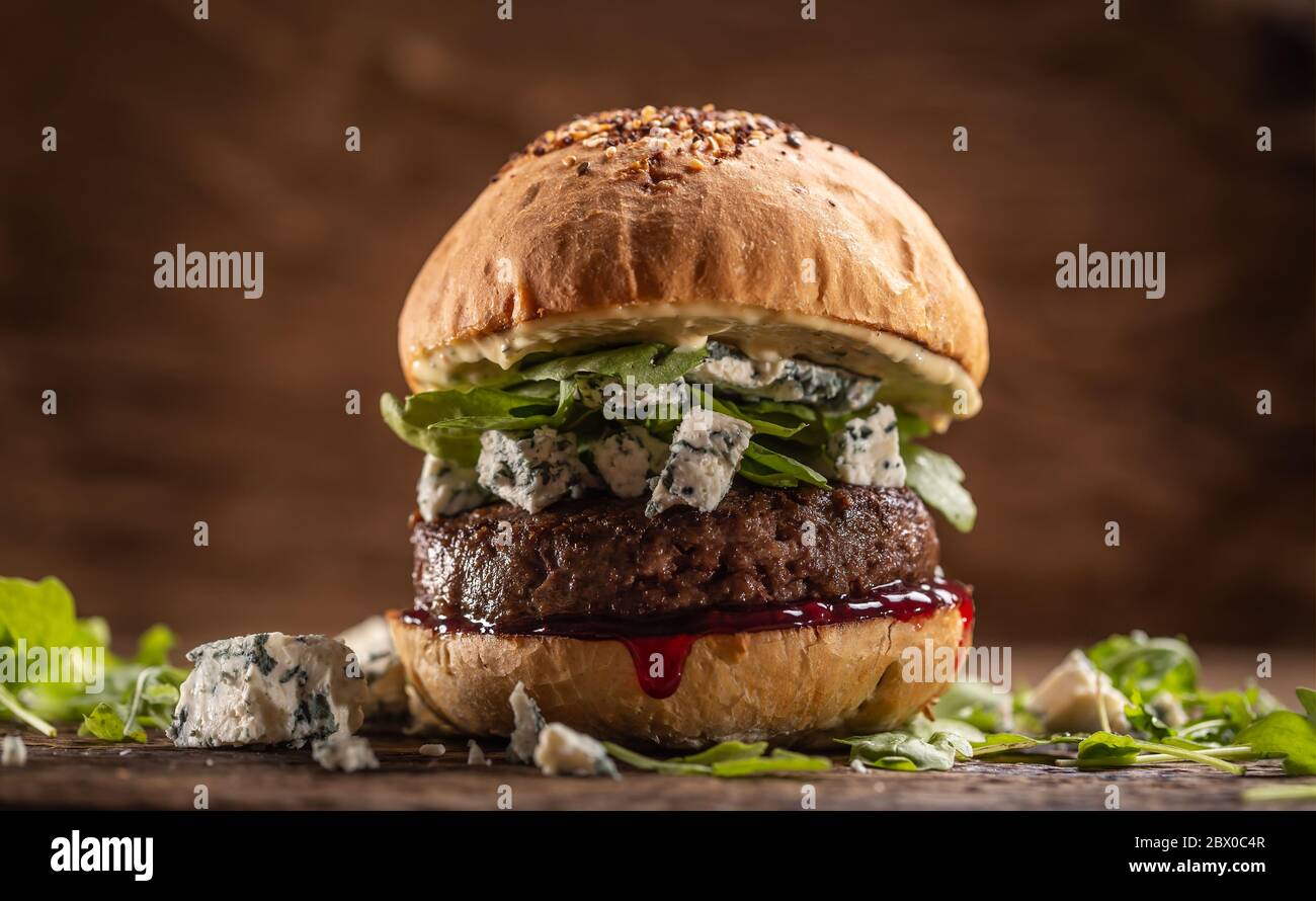 Hamburger di manzo con rucola, formaggio blu e salsa di mirtilli Foto Stock