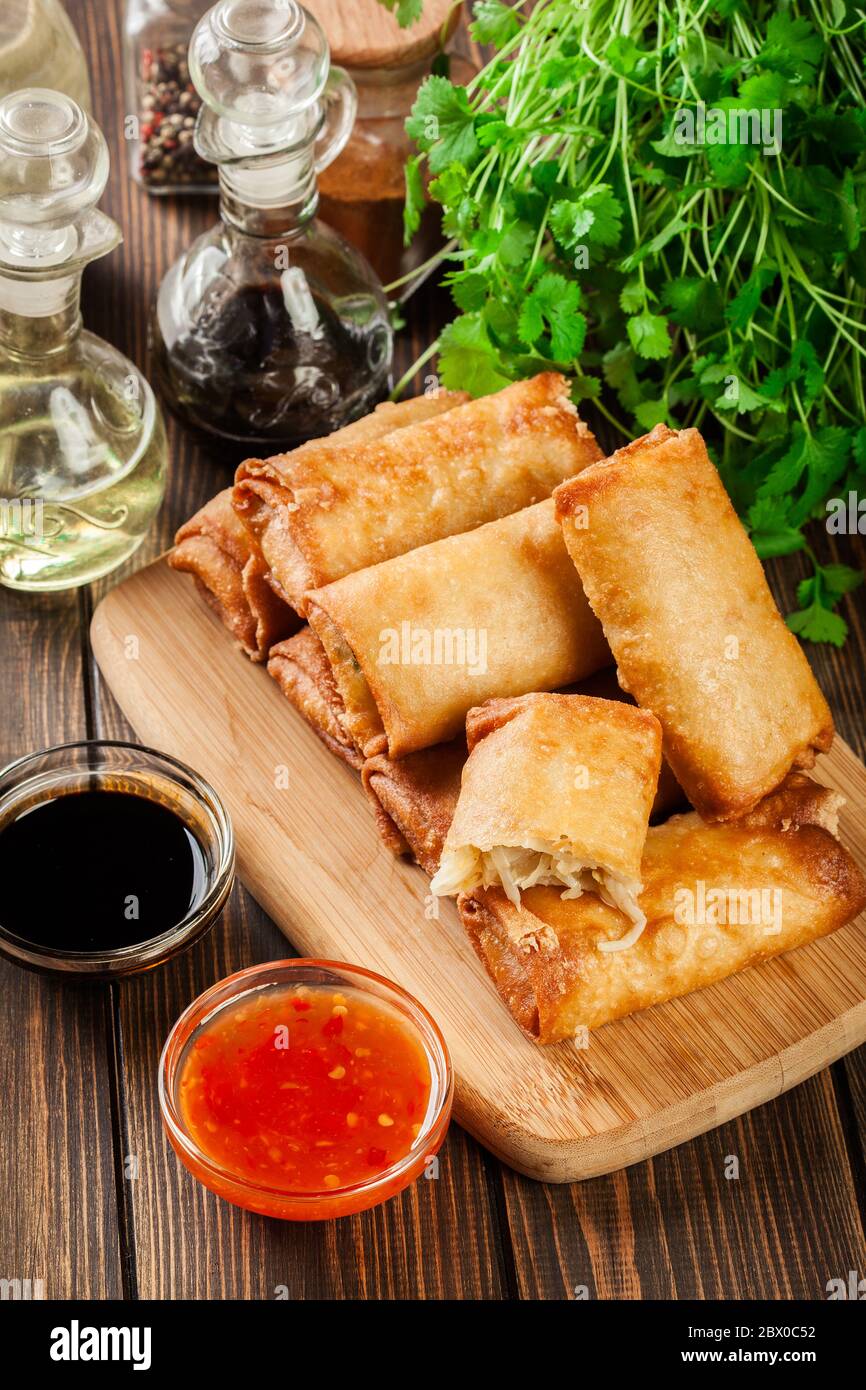 Involtini primavera con pollo e verdure sul tagliere. Cucina asiatica. Foto Stock