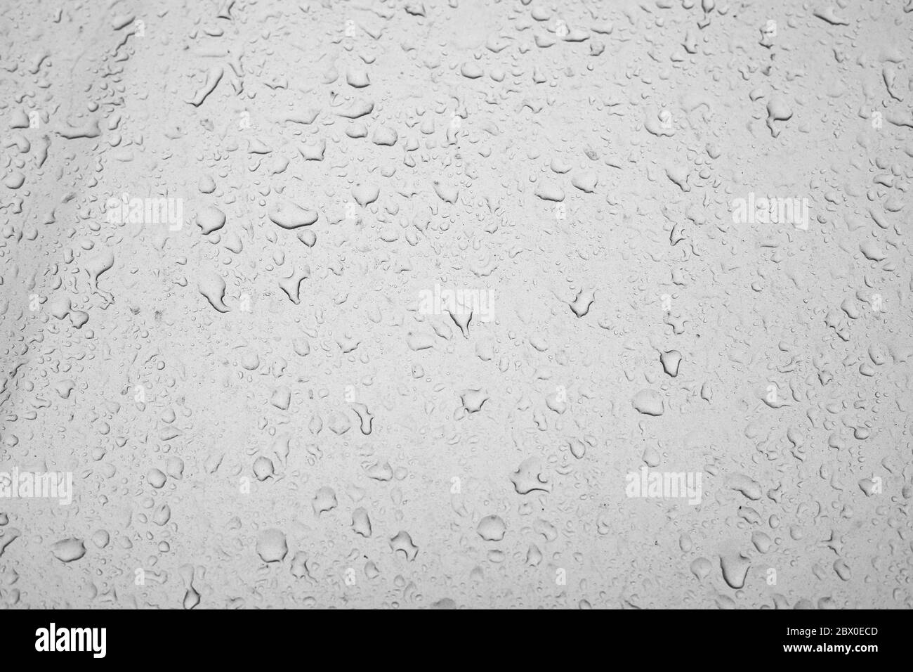 consistenza di gocce d'acqua su una finestra sporca, gocce di pioggia su un vetro dell'automobile, precipitazioni atmosferiche primavera d'autunno, effetto textured sfondo attesa f Foto Stock