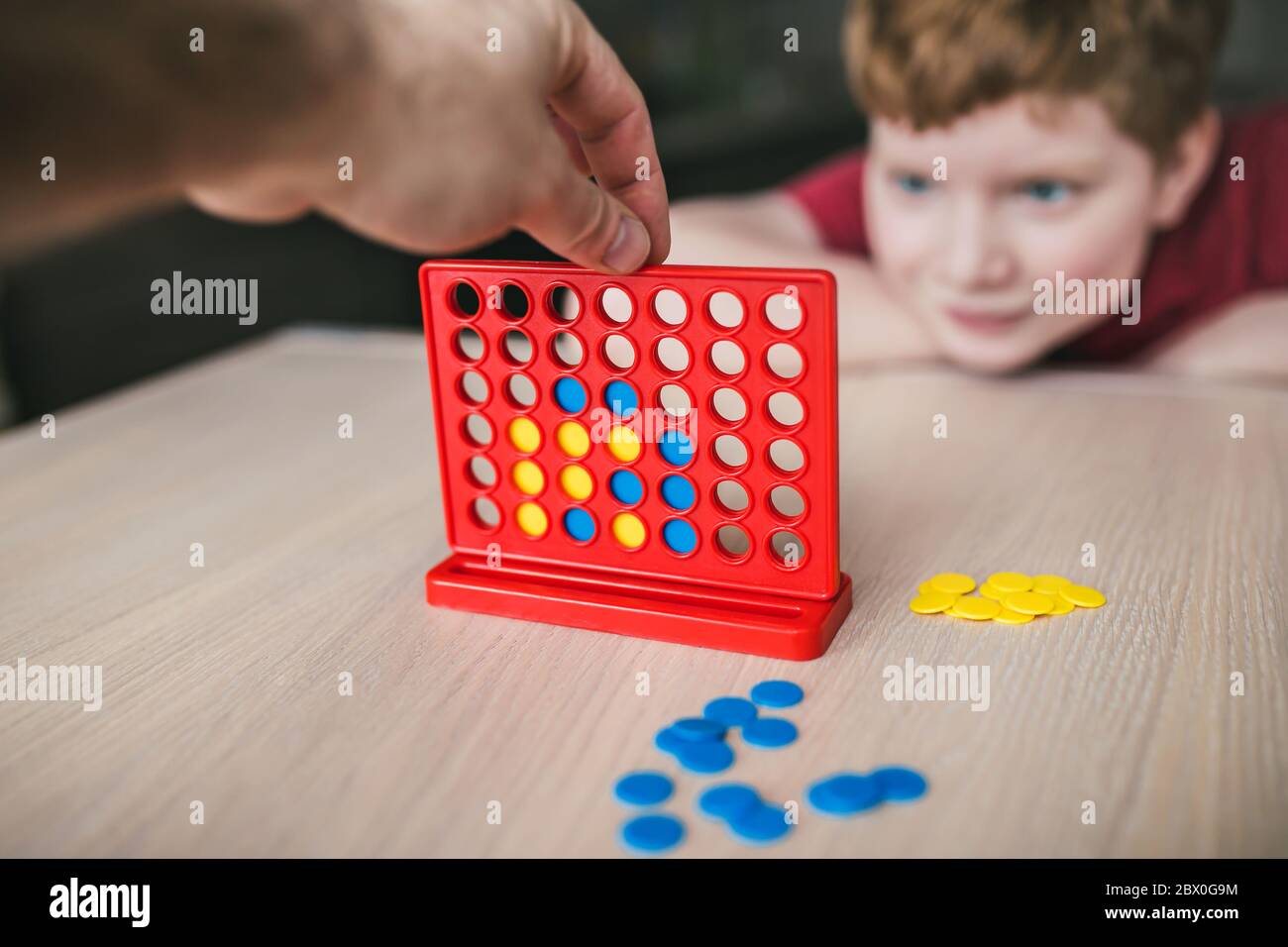 Padre e figlio giocano un gioco da tavolo di 'Collect Four in a line' - tempo libero per la famiglia Foto Stock