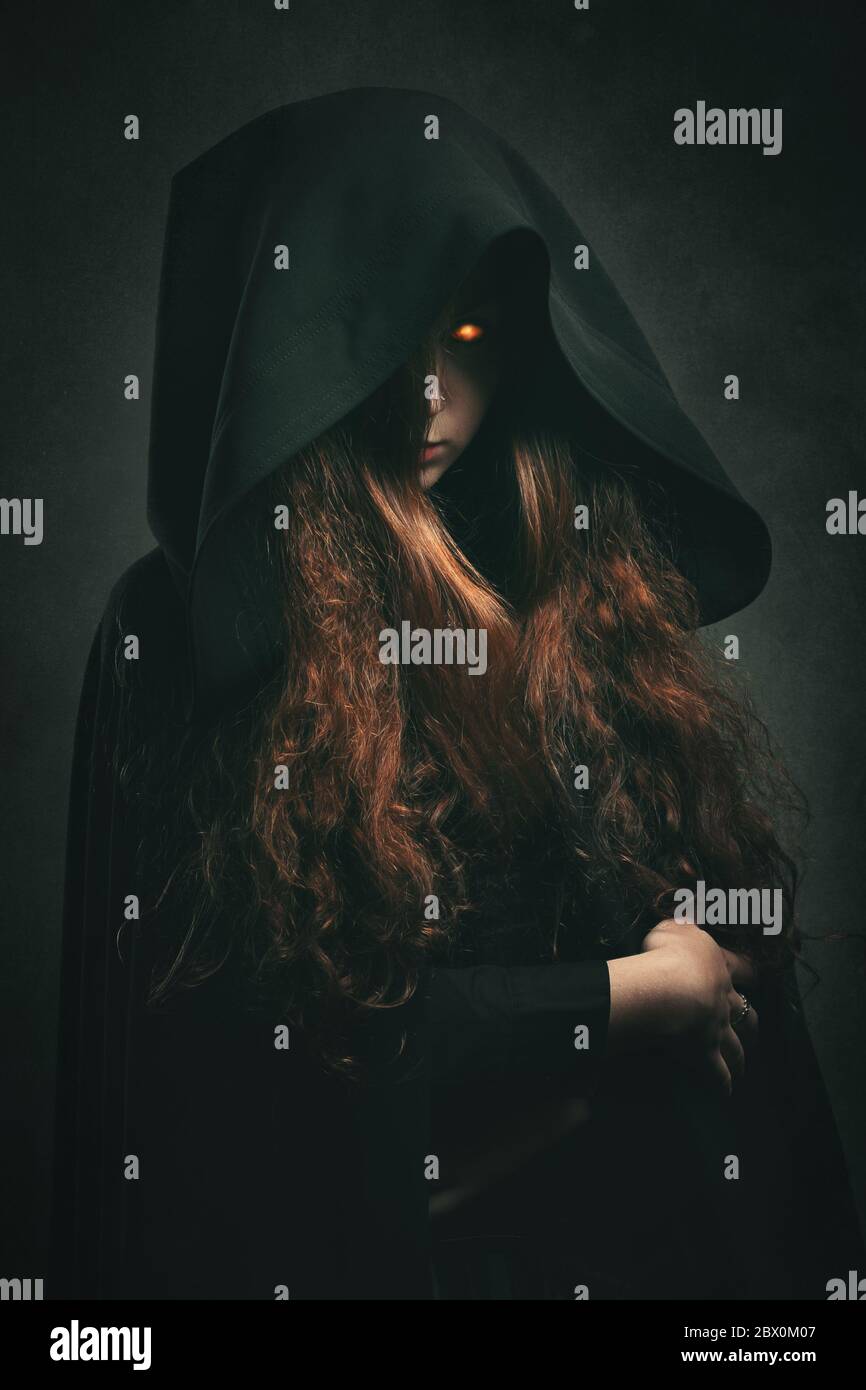 Strega del fuoco con accappatoio nero . Ritratto fantasy scuro Foto Stock