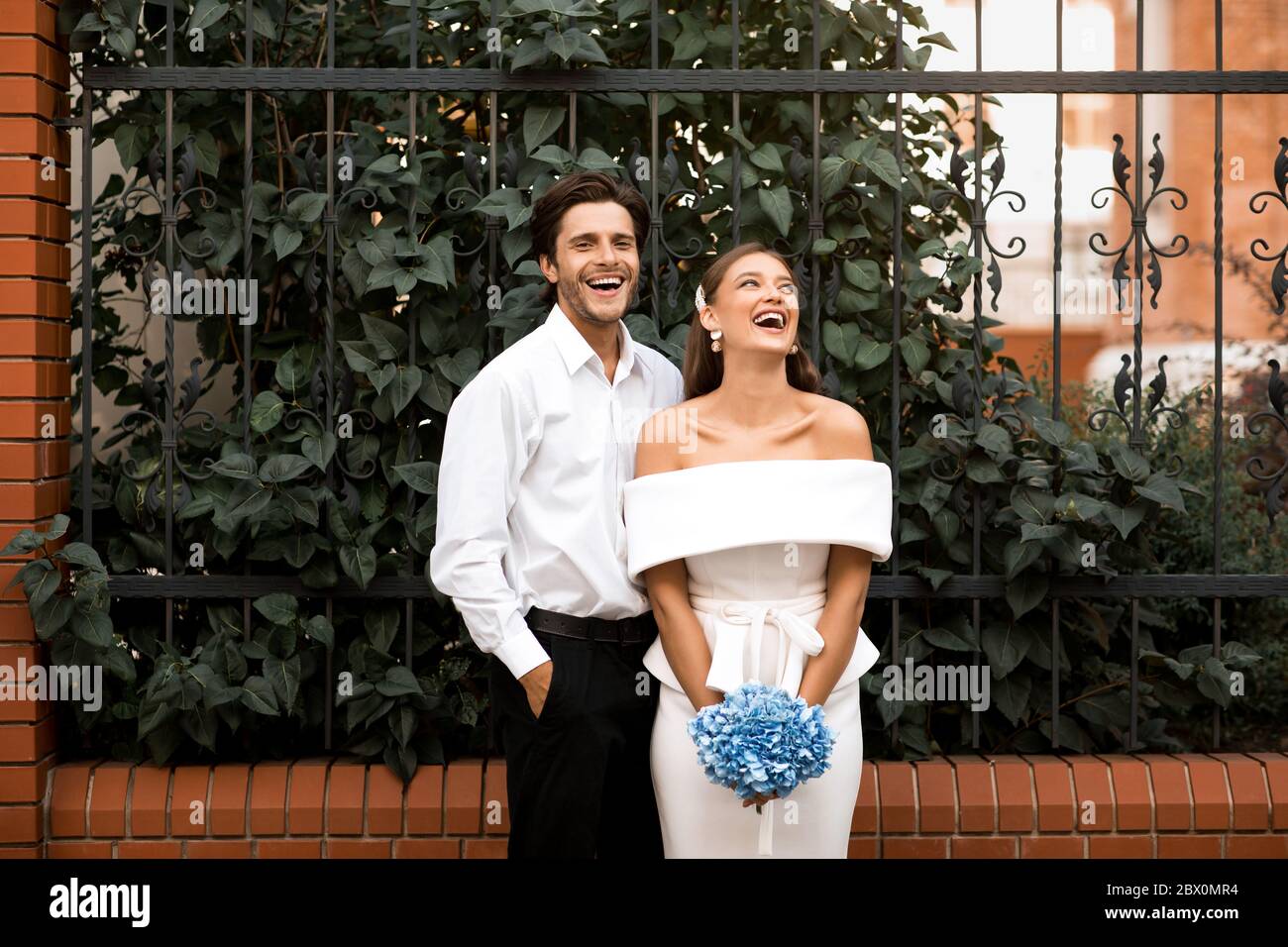 Sposato con Bride e Grroom Laughing Standing Outdoors Foto Stock