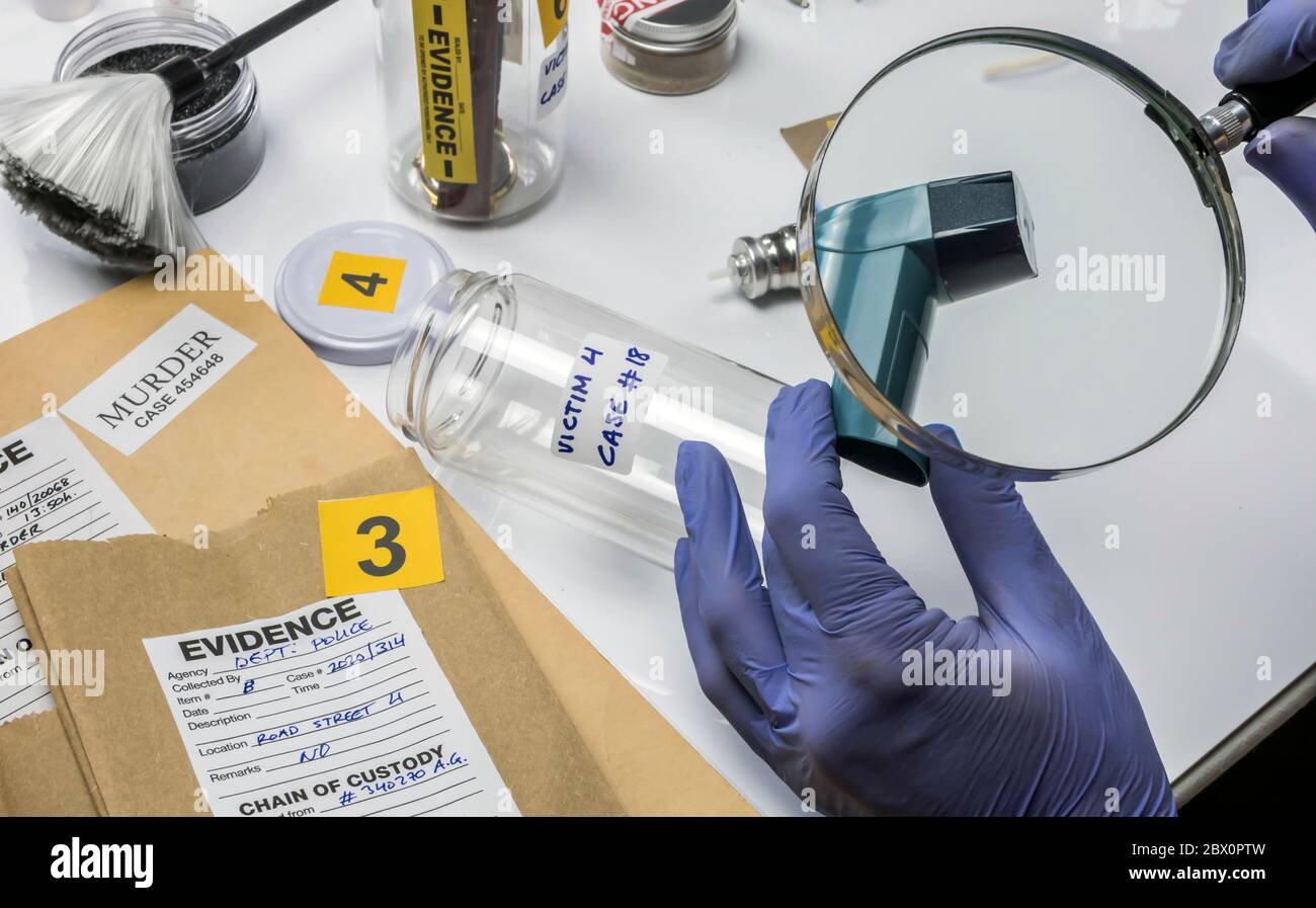 Polizia criminale specializzata alla ricerca di stampe con una lente di ingrandimento su un inalatore di una vittima di crimine, immagine concettuale Foto Stock