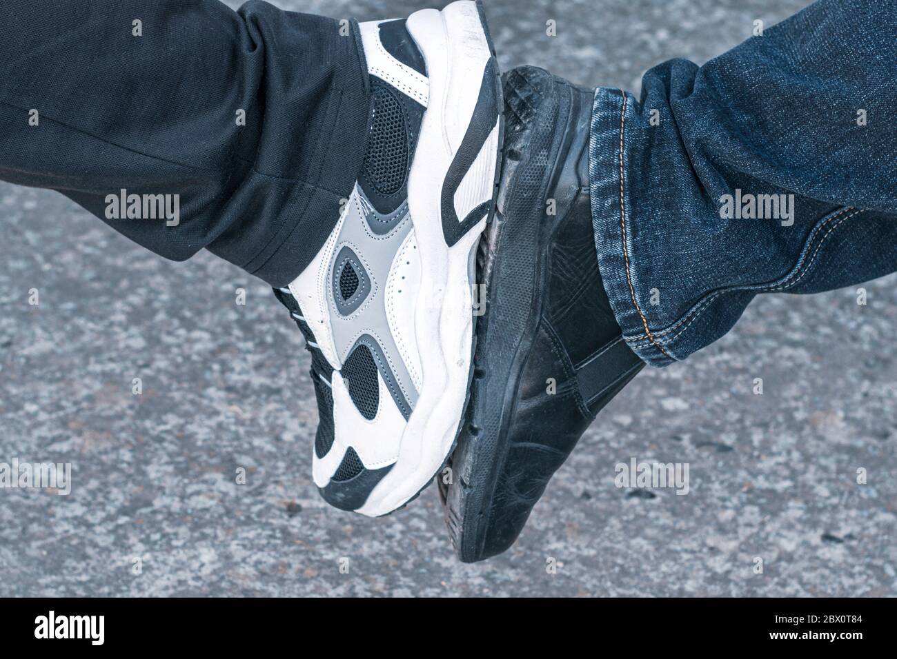 concetto di pandemia sicura saluto due gambe a contatto con le suole delle scarpe Foto Stock