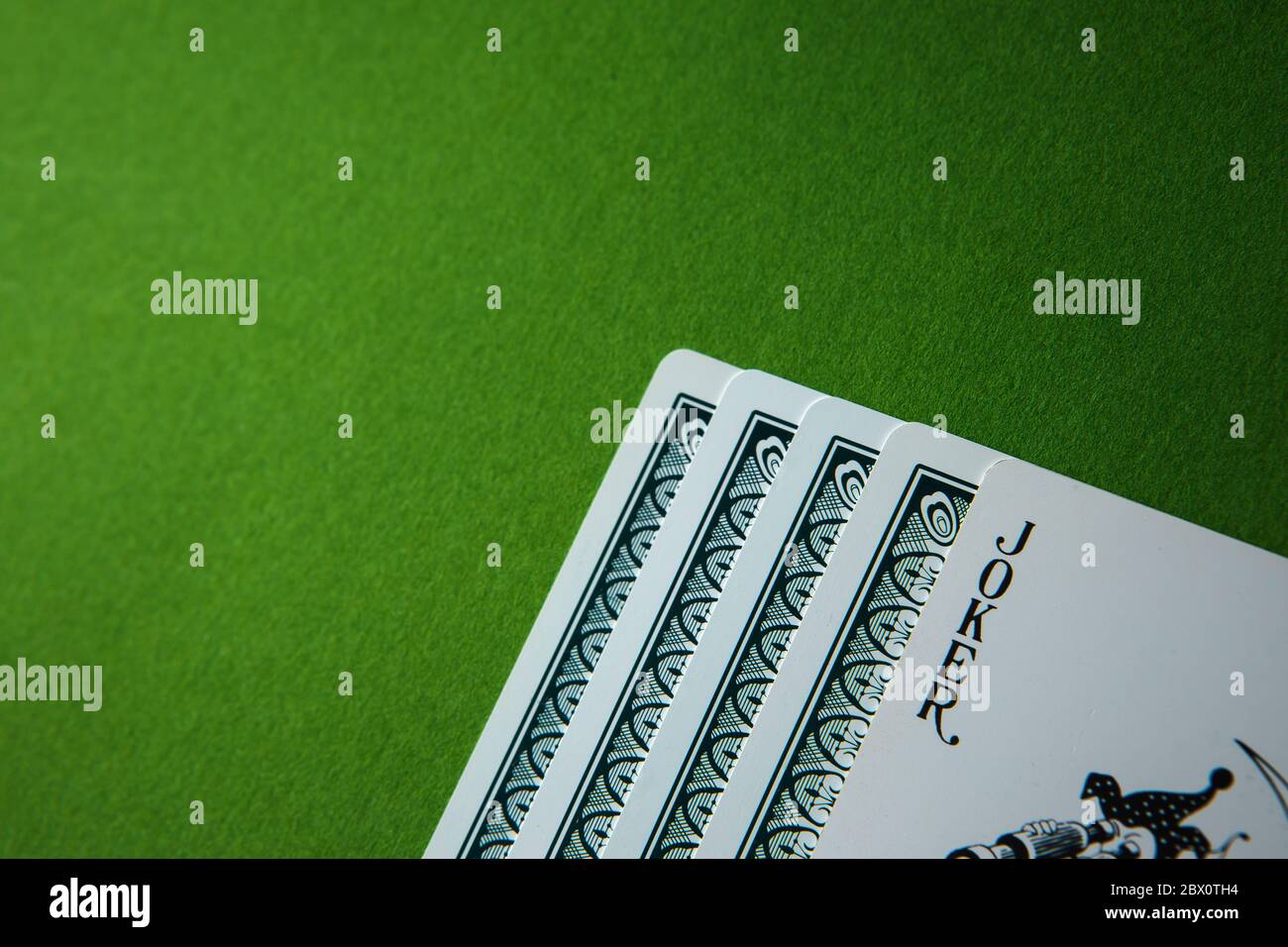 Carta da gioco Joker su sfondo verde. Foto Stock