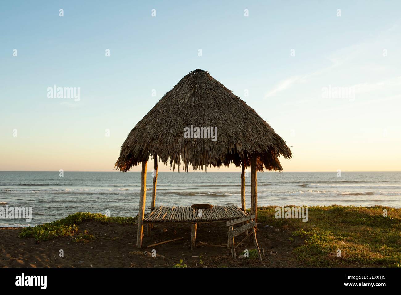 Paesaggio costiero con tetto di paglia spiaggia palapa. El Paredón, costa del Pacifico, Guatemala Foto Stock