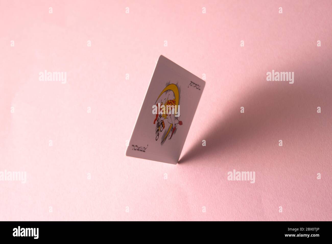 Joker carta da gioco su sfondo rosa. Foto Stock