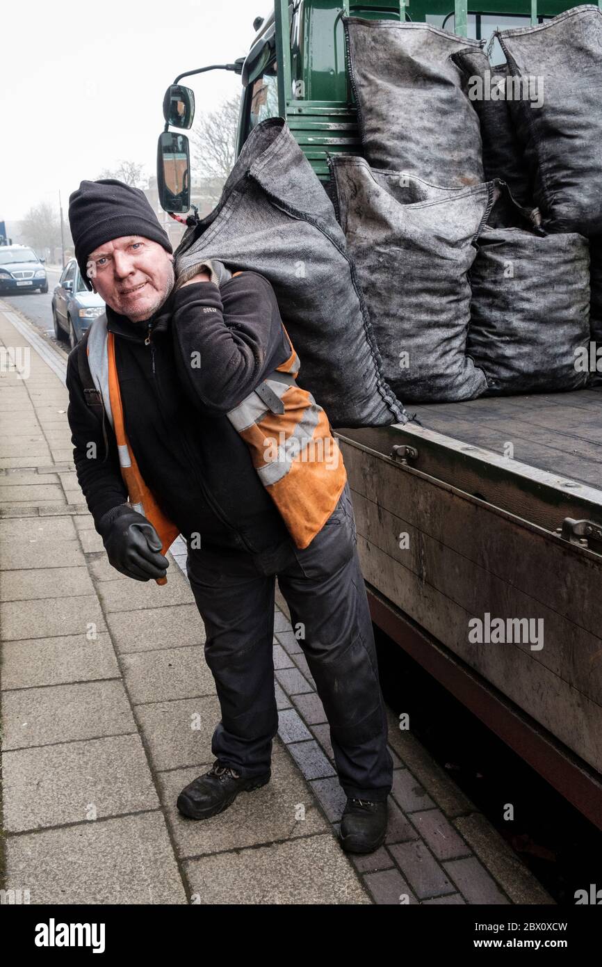 Un uomo di coaleria che consegna sacchi di carbone in una strada a Longton, Stoke on Trent, Staffordshire, Inghilterra Foto Stock