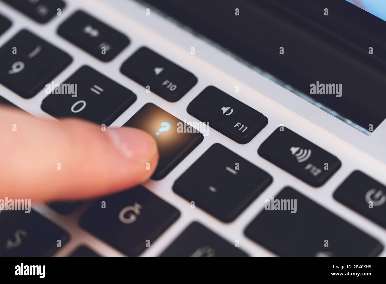 Primo piano del dito dell'uomo che tocca il tasto lettera punto  interrogativo sulla tastiera nera del computer Foto stock - Alamy