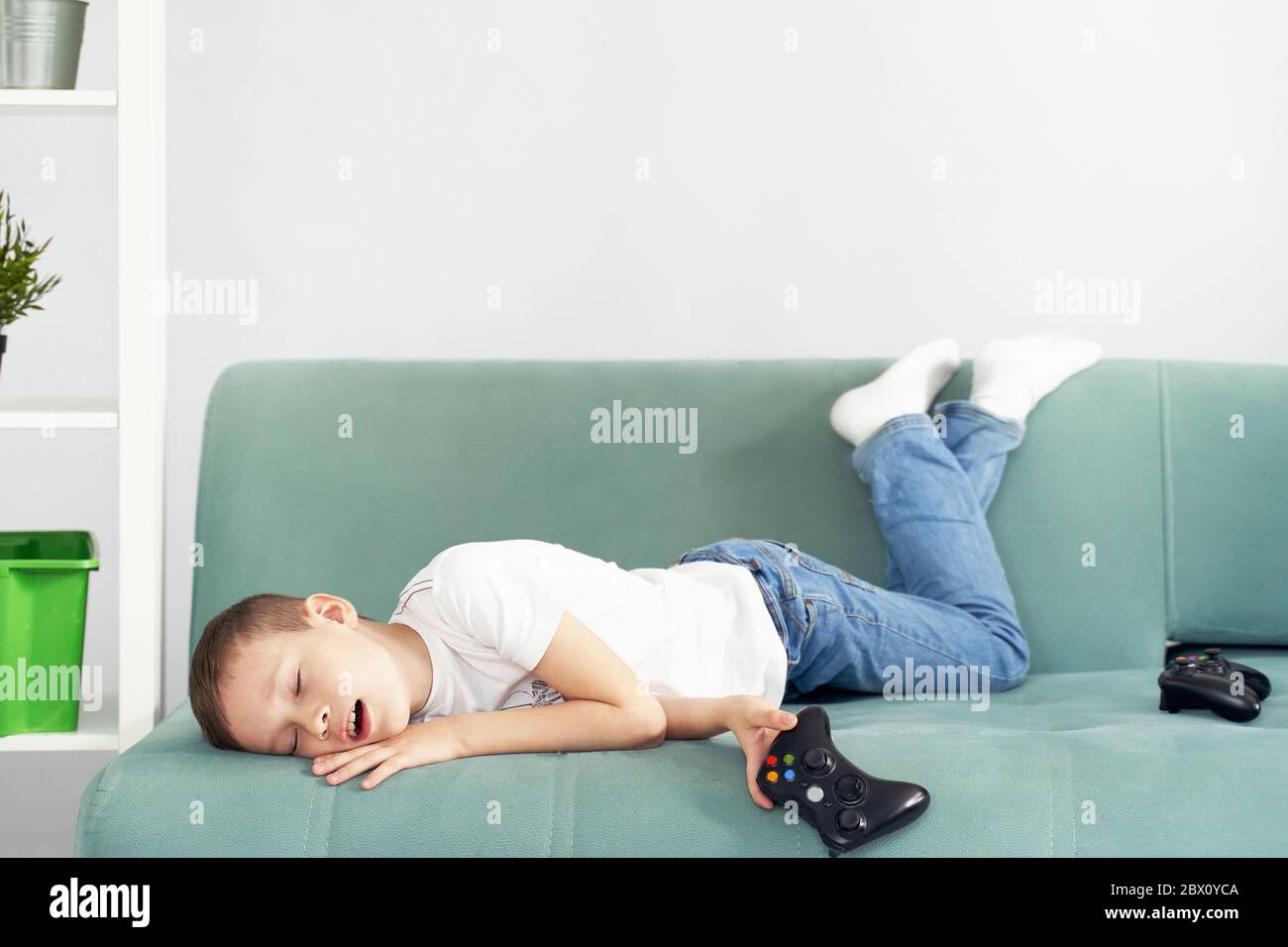 il bambino si è addormentato dopo aver giocato ai videogiochi Foto Stock