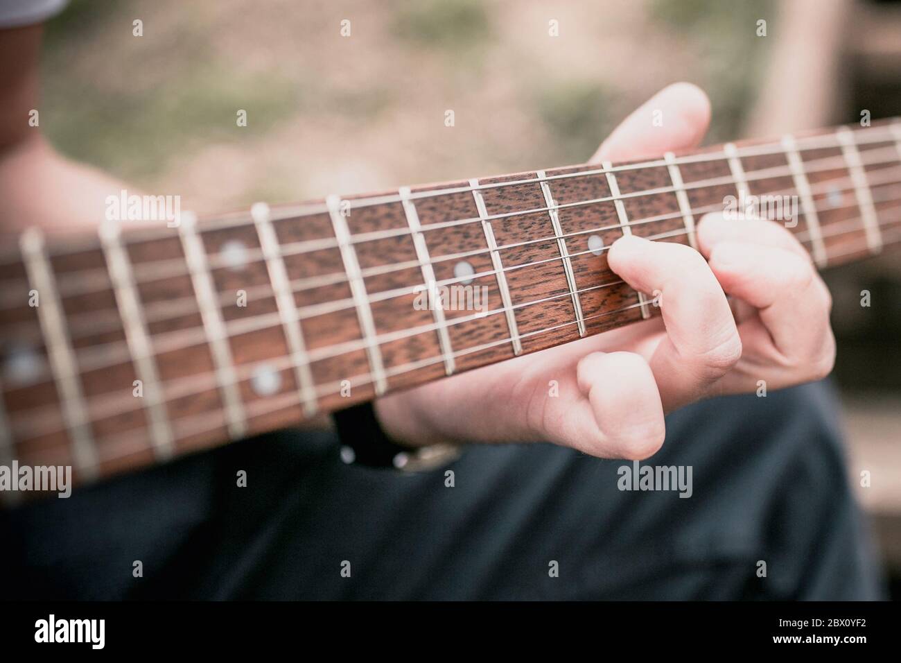 Primo piano di una mano dell'uomo che gioca all'aperto - hard hard rock e musica blues - accordi e solos Foto Stock