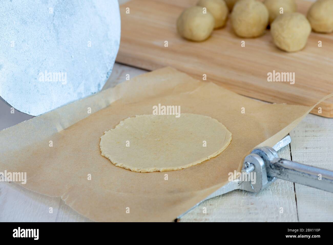 Fare autentiche tortillas di mais - palla di impasto pressata piatta da torciglia. Foto Stock