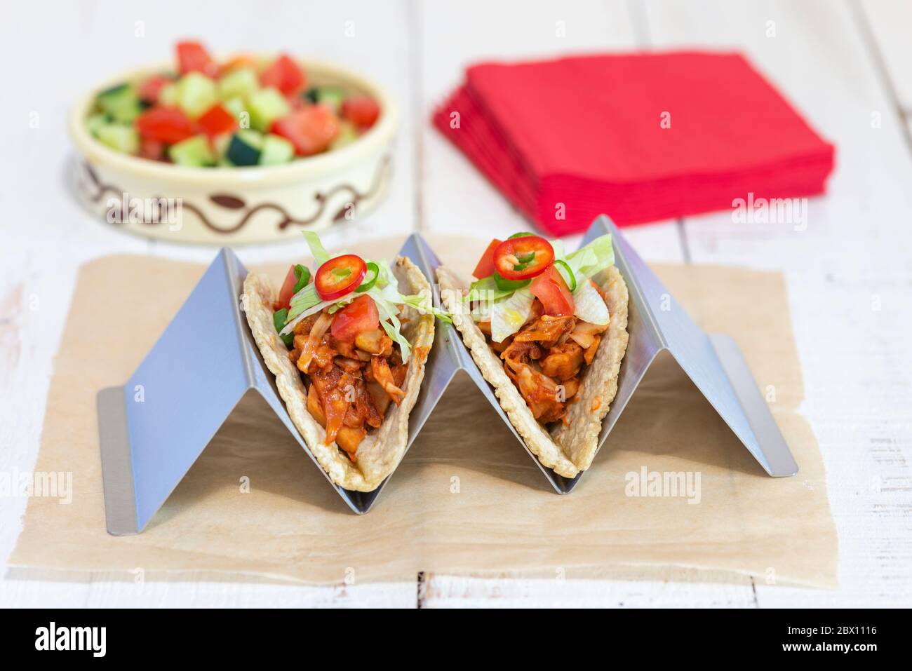 Due tacos vegan trainati con jackfruit realizzati con tortillas di mais morbido in un supporto per tortilla. Foto Stock