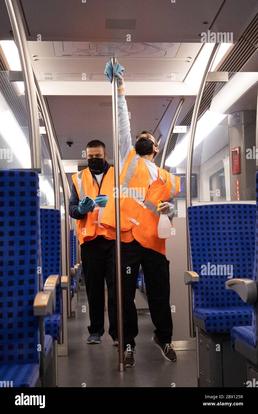 04 giugno 2020, Amburgo: I membri di un team di igiene della DB-Service per la S-Bahn di Amburgo lavorano su un treno S-Bahn durante un viaggio attraverso il raccordo di svolta alla stazione di Altona. In occasione di un evento mediatico di giovedì, S-Bahn, VHH (Verkehrsbetriebe Hamburg-Holstein GmbH) e Hochbahn hanno fornito informazioni sui team di igiene mobile in autobus, treni e fermate. D'ora in poi, oltre alla pulizia quotidiana di tutti i veicoli e delle strutture, effettueranno misure di pulizia disinfettanti durante le operazioni in corso come misura precauzionale contro la pandemia della corona. Foto: Christian Charisius/dpa Foto Stock