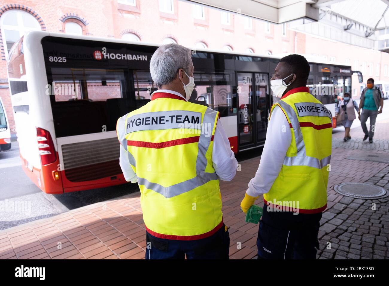 04 giugno 2020, Amburgo: Mehmet Ince (l) e Abdul Razak Alidu, membri di un team di igiene Tereg per l'Hamburger Hochbahn, sono in attesa di un autobus alla stazione di Altona. In occasione di un evento mediatico di giovedì, S-Bahn, VHH (Verkehrsbetriebe Hamburg-Holstein GmbH) e Hochbahn hanno fornito informazioni sui team di igiene mobile in autobus, treni e fermate. D'ora in poi, oltre alla pulizia quotidiana di tutti i veicoli e delle strutture, effettueranno misure di pulizia disinfettanti durante le operazioni in corso come misura precauzionale contro la pandemia della corona. Foto: Christian Charisius/dpa Foto Stock