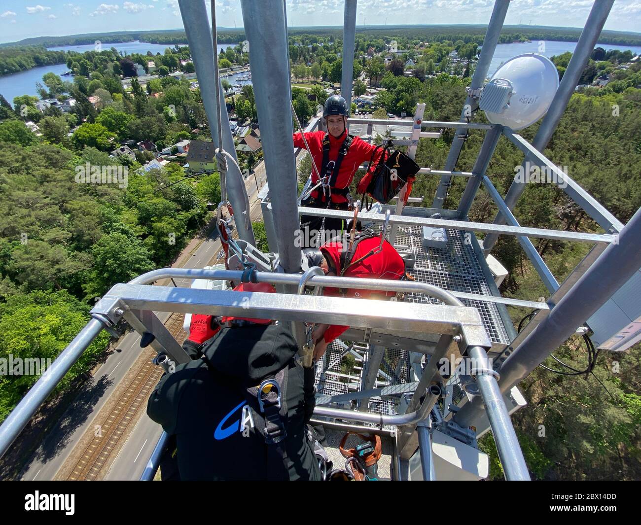 Berlino, Germania. 26 Maggio 2020. I lavoratori installano antenne per la quinta generazione di comunicazioni mobili (5G) su un palo radio nel quartiere berlinese di Schmöckwitz a un'altezza di 50 metri. Vengono utilizzati i cosiddetti sistemi MIMO ad antenna multipla (Multiple Input Multiple Output), che possono trasportare volumi di dati estremamente elevati con tempi di latenza ridotti nelle comunicazioni mobili 5G. Credit: Christoph Dernbach/dpa/Alamy Live News Foto Stock