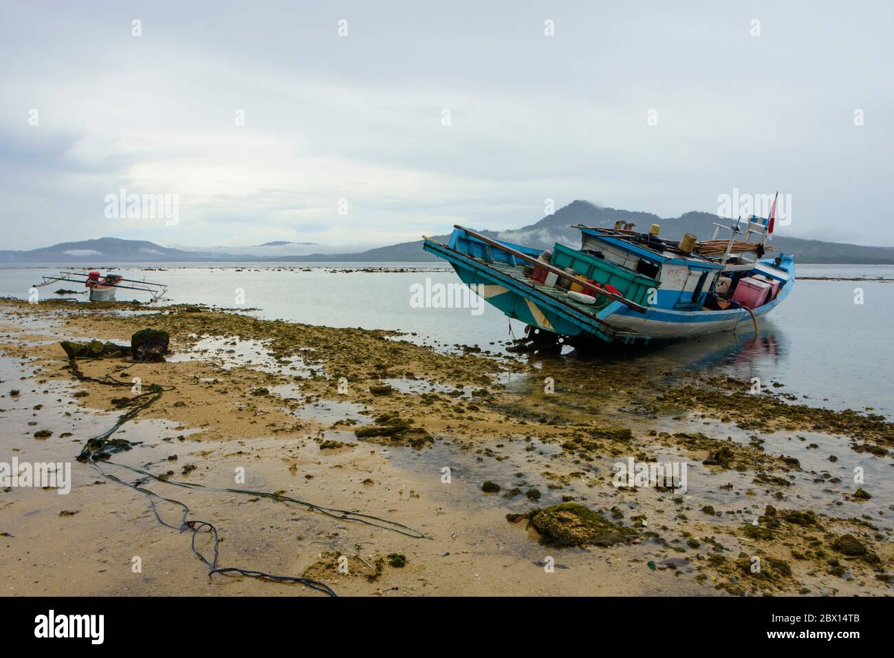 Barca sbloccata sulla spiaggia di Bunaken, Sulawesi Nord, Indonesia. Foto Stock