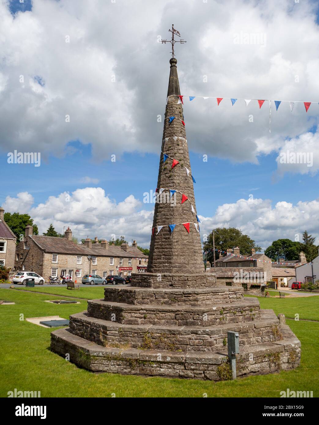 Il mercato di pietra sostanziale croce sul verde villaggio in Burton ovest nel Parco Nazionale Yorkshire Dales Foto Stock