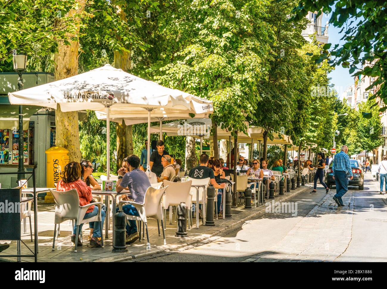 Granada, Spagna, juli 1, 2017: Turisti seduti sulla terrazza in strada a Plaza de la Trinidad Foto Stock