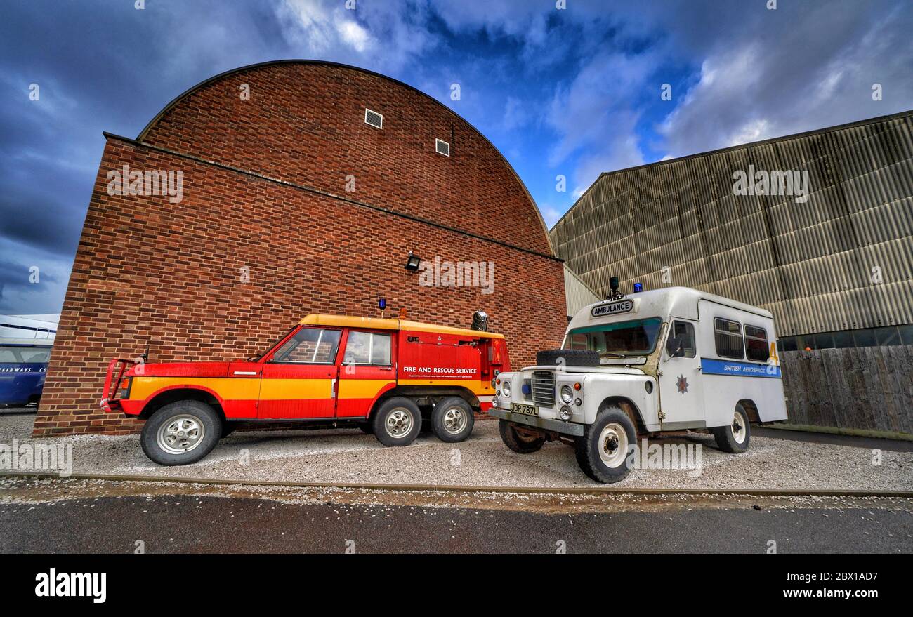 L'auto Fire and Rescue Service e l'auto British Aerospace hanno parcheggiato di fronte a un enorme capanno di volo come parte della British Heritage Expo al Brooklands Museum. Foto Stock
