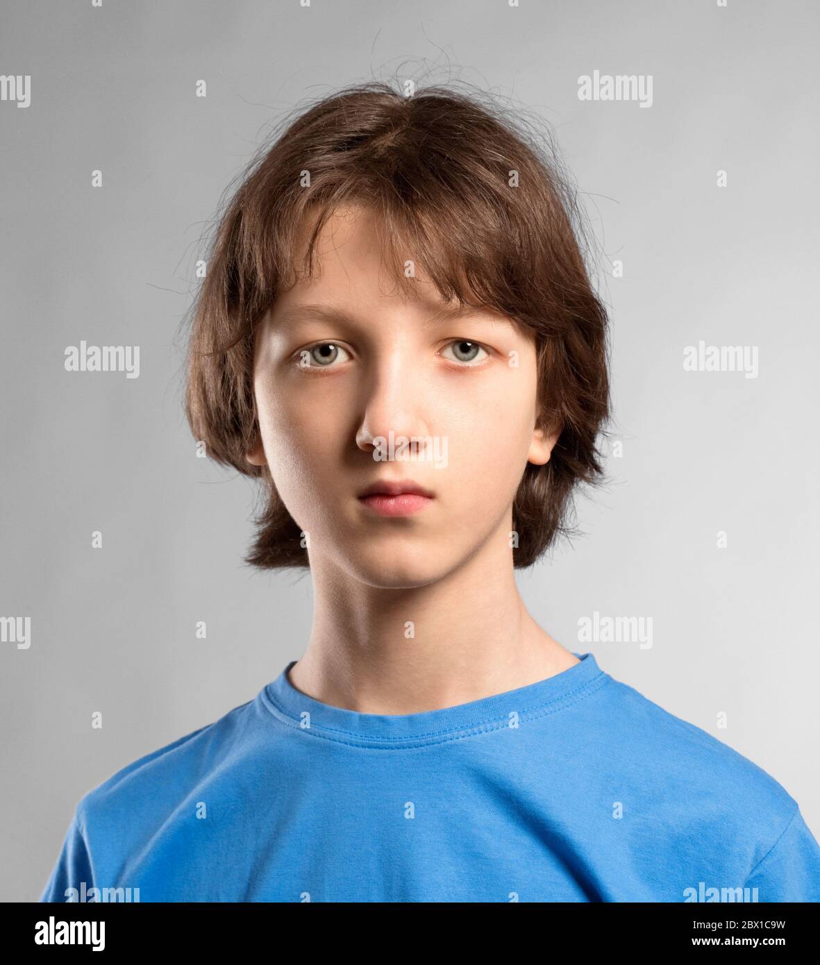 Ritratto di un ragazzo di teenage con capelli marroni in Blue Top. Foto Stock