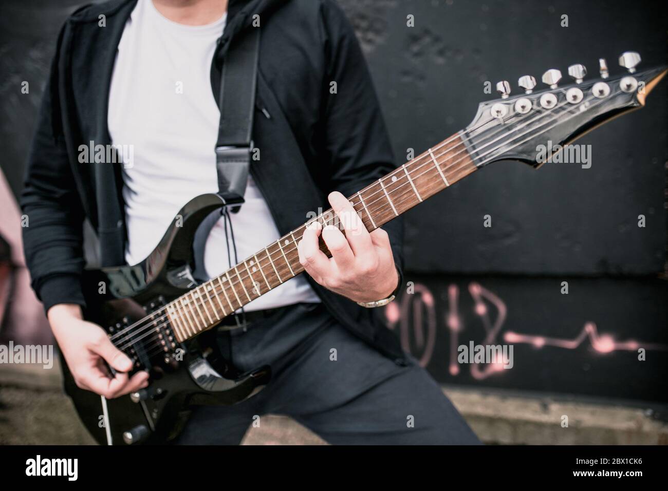 Primo piano di una mano dell'uomo che gioca all'aperto - hard hard rock e musica blues - accordi e solos Foto Stock