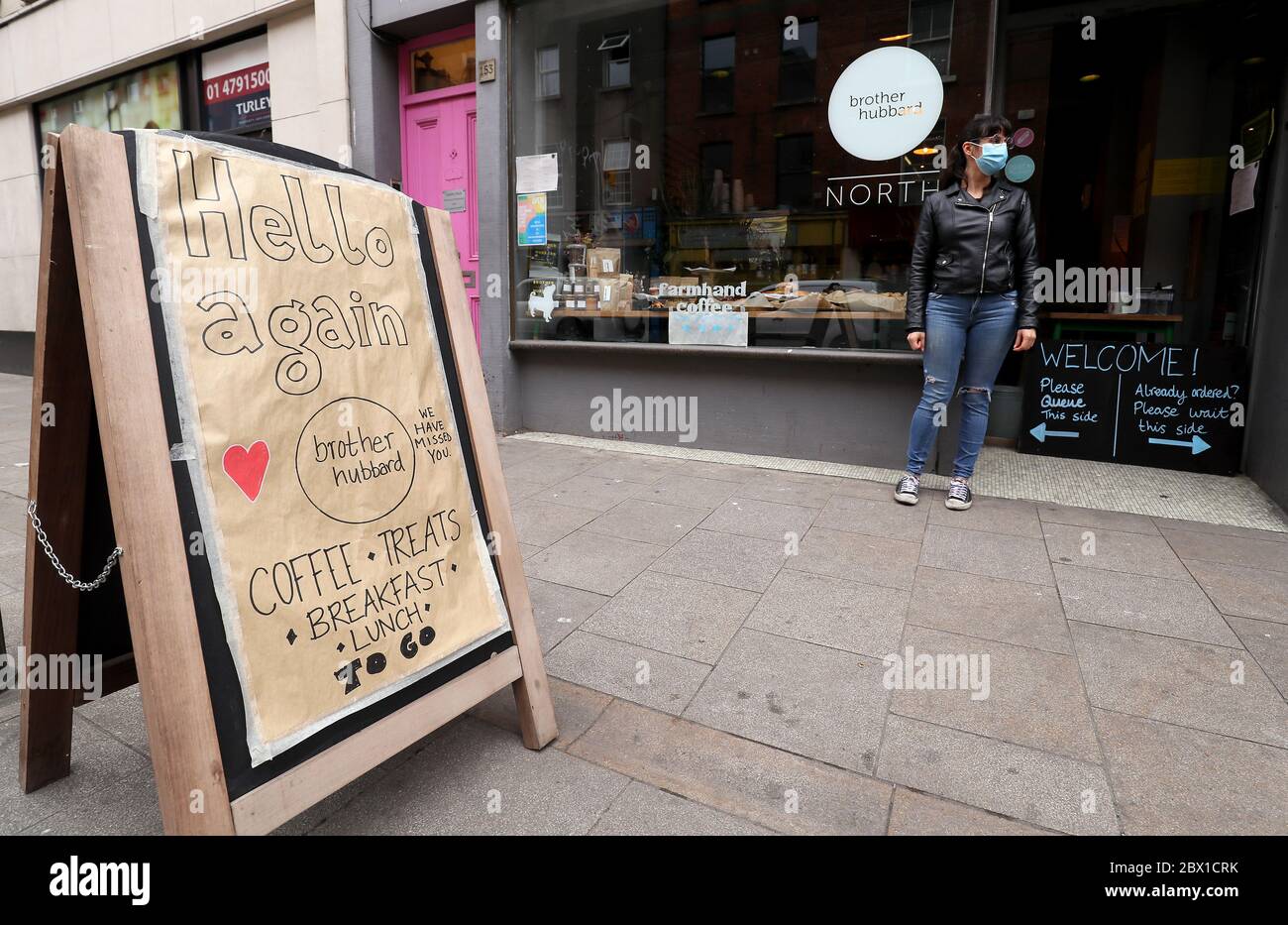 Un membro del personale di una caffetteria nel centro di Dublino si prepara per la giornata, come ci si aspetta che i piccoli punti vendita al dettaglio possano riaprire da lunedì con un numero ridotto di personale, a condizione che il rivenditore possa controllare il numero di clienti che entrano nel negozio. Foto Stock