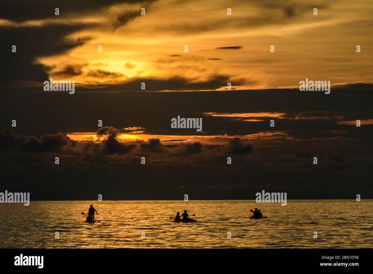 Canoers al sunsut all'isola di Bunaken, Sulawesi del Nord, Indonesia. Foto Stock