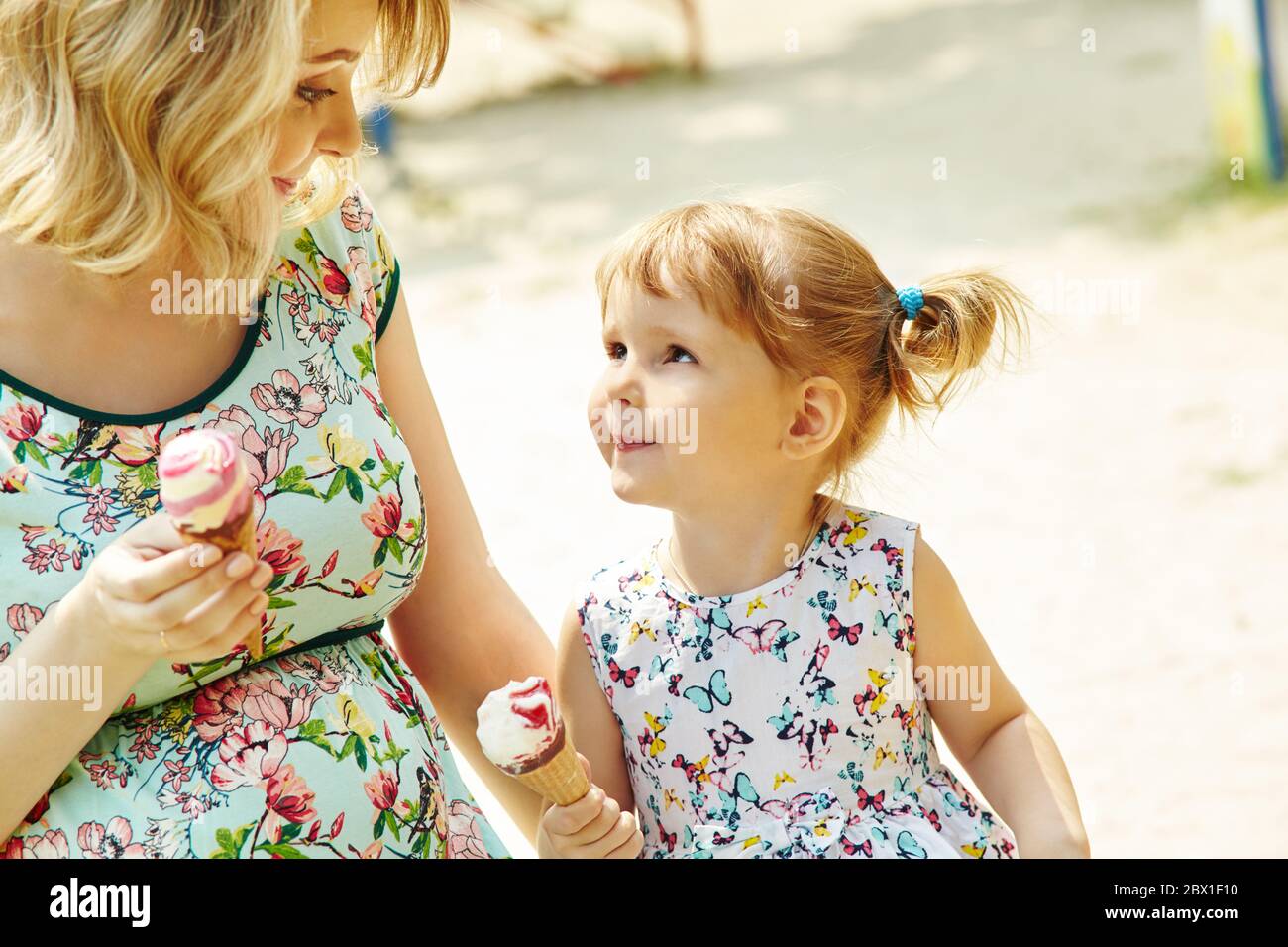 Mamma e bambino mangiano gelato, madre e figlia all'aperto. Foto Stock