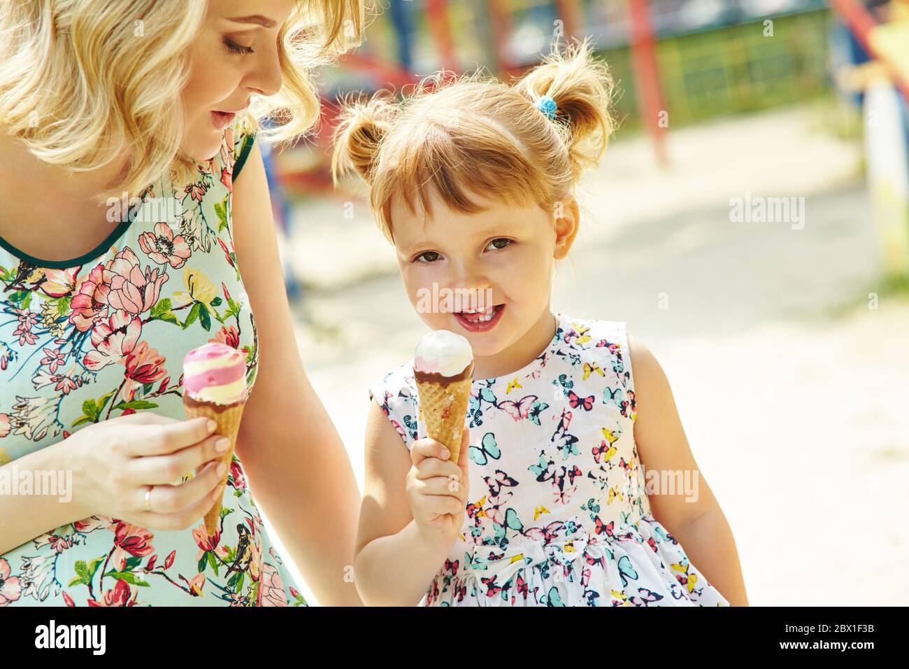 Mamma e bambino mangiano gelato, madre e figlia all'aperto. Foto Stock