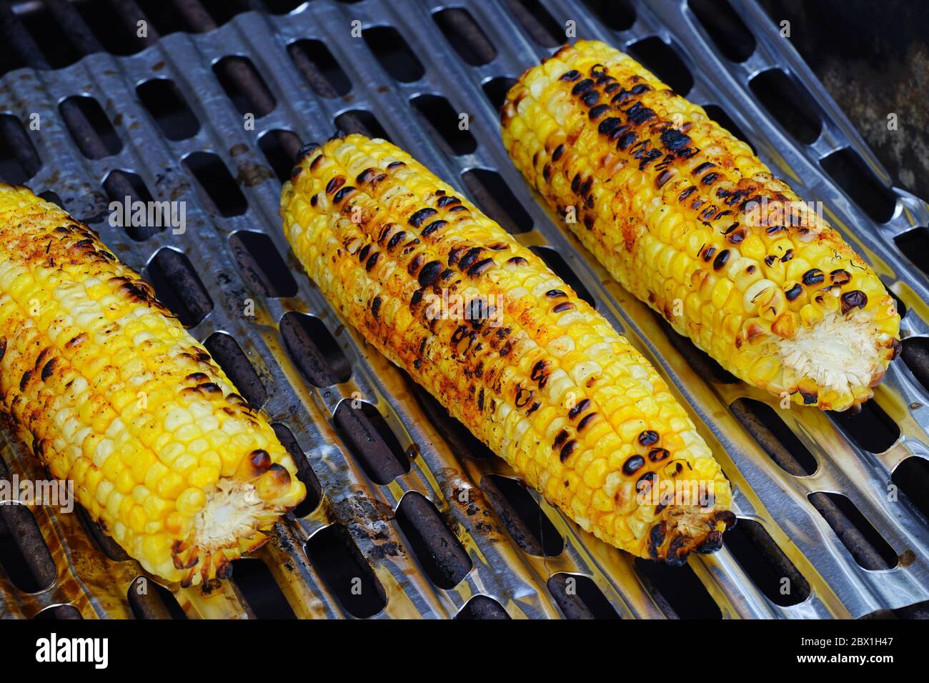 Grigliare il mais sulla pannocchia su un barbecue Foto Stock