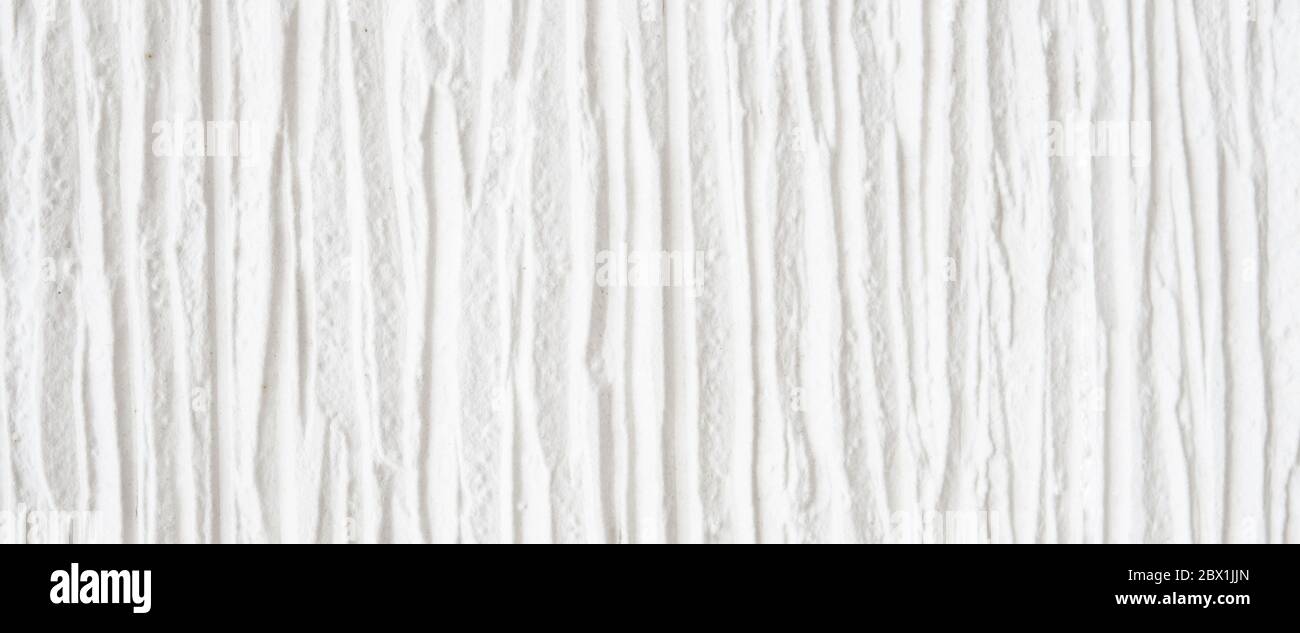 Splendido sfondo bianco a strisce. Frammento di dettagli elevati della superficie testurizzata in pietra bianca. Foto Stock