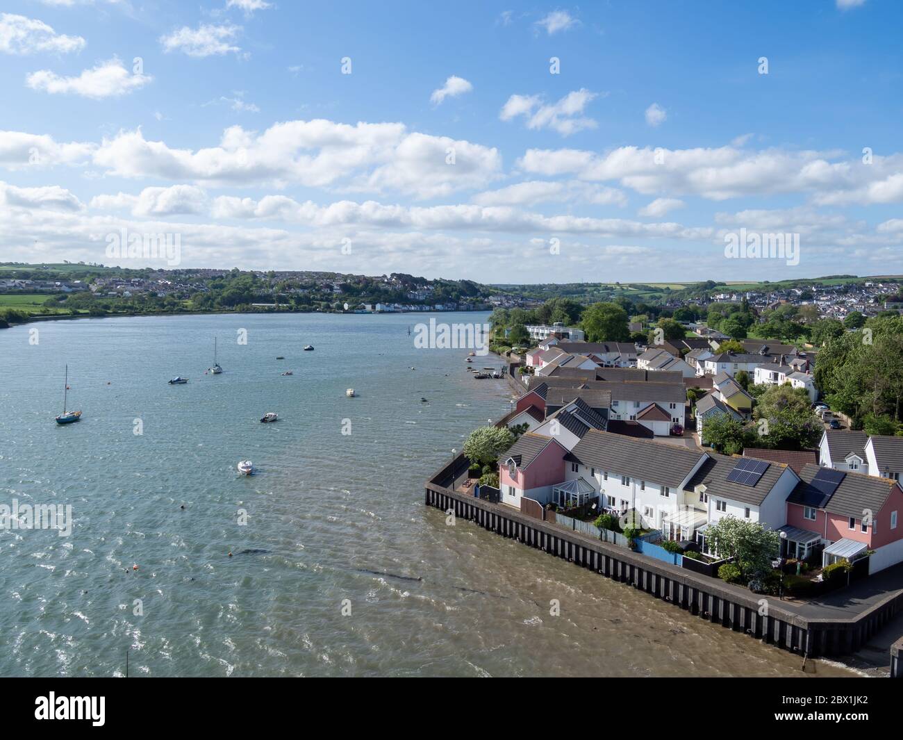 BIDEFORD, DEVON, UK - MAGGIO 11 2020: Nascondi la marea sul fiume Torridge. Case all'interno di difese alluvionali. Sviluppo residenziale. Foto Stock