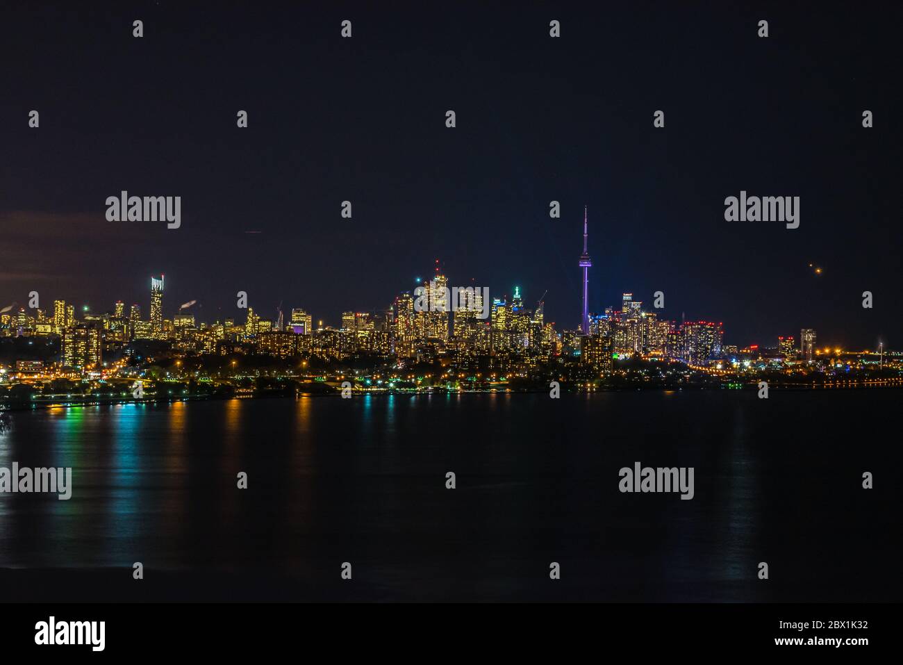 Skyline di Toronto oltre il Lago Ontario durante la notte. Foto Stock