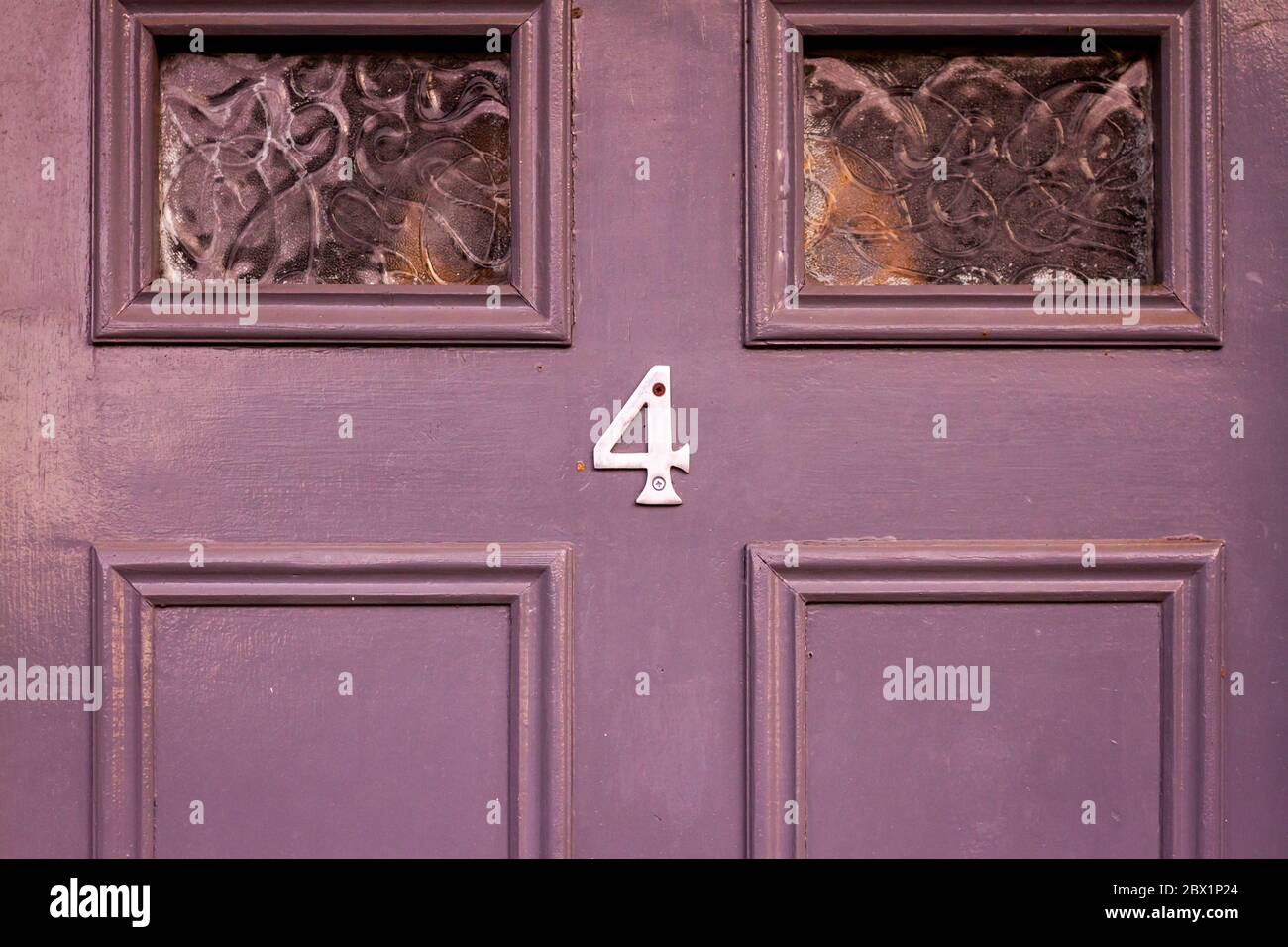 Casa numero 4 su una porta di legno viola Foto Stock