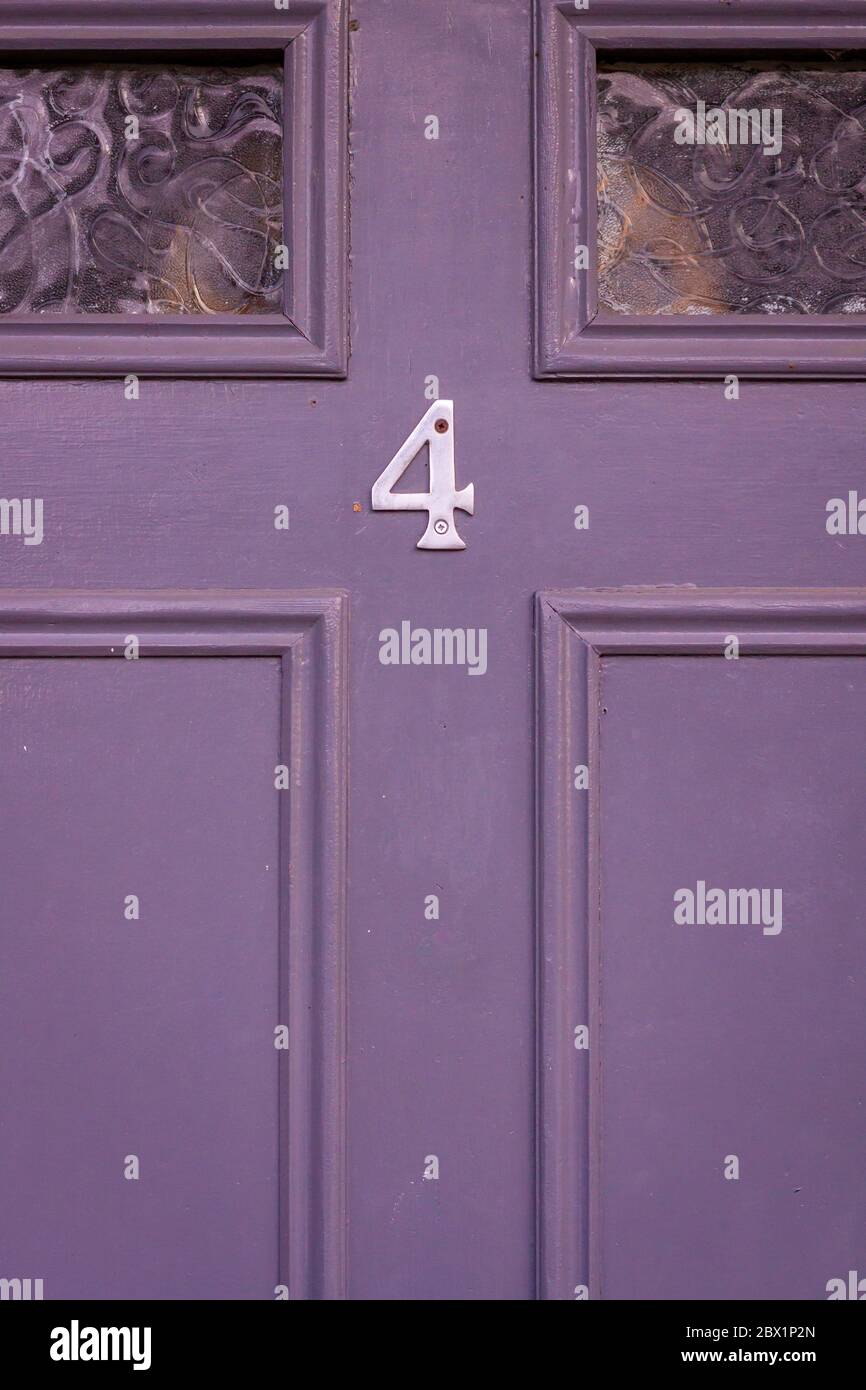 Casa numero 4 su una porta di legno viola Foto Stock