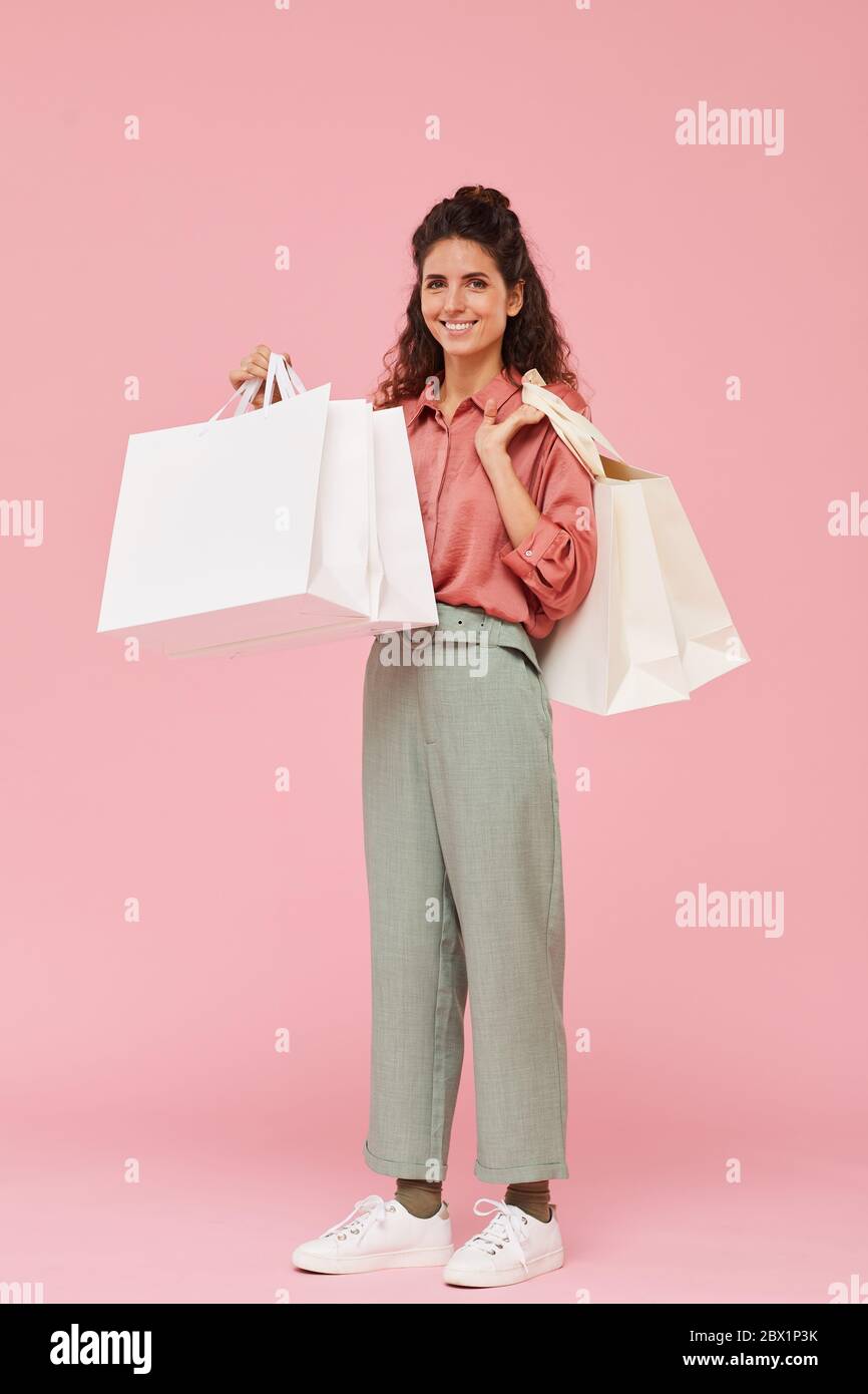 Ritratto di felice giovane donna in piedi e tenere borse di shopping che si è soddisfatta con lo shopping Foto Stock