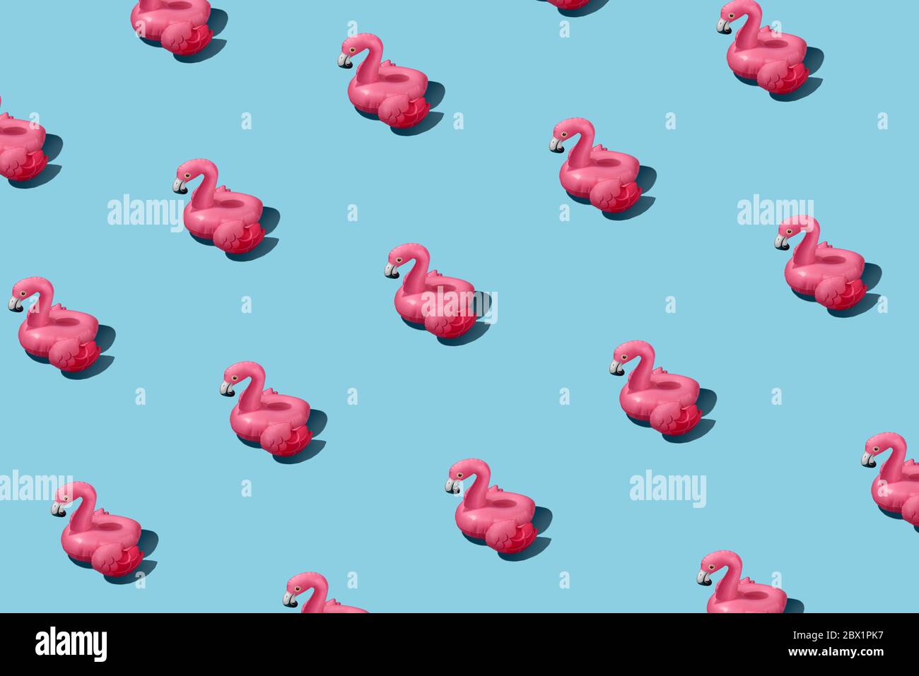 Modello alla moda con fenicottero rosa gonfiabile su sfondo blu Foto Stock