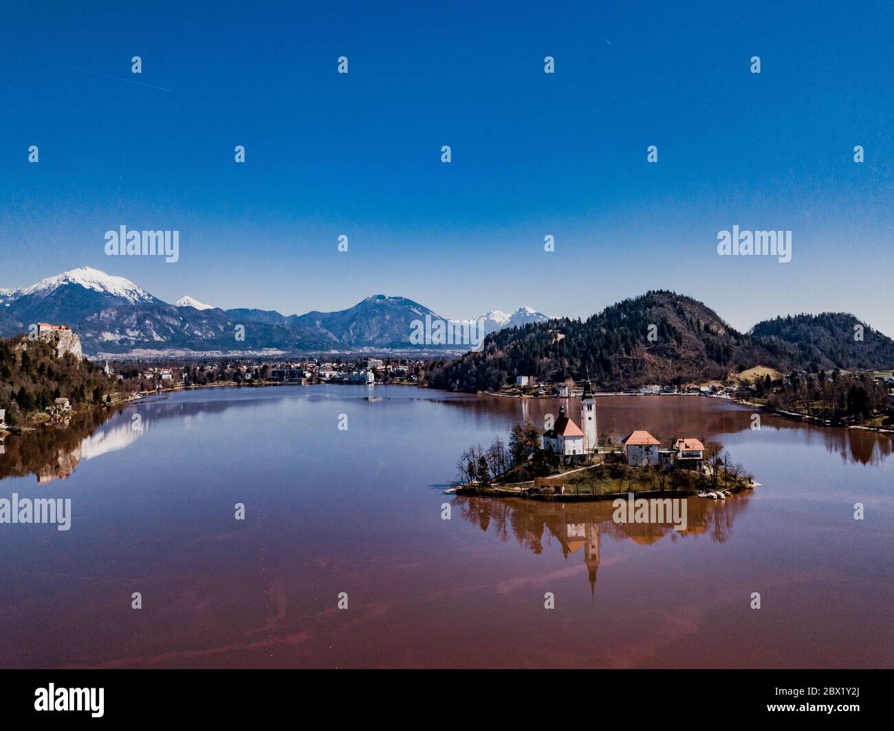 Famoso lago di colore rosso e isola Bled (Blejsko jezero) in Slovenia. Bellissimo lago alpino di montagna con Chiesa del pellegrinaggio dell'Assunzione di Maria A. Foto Stock