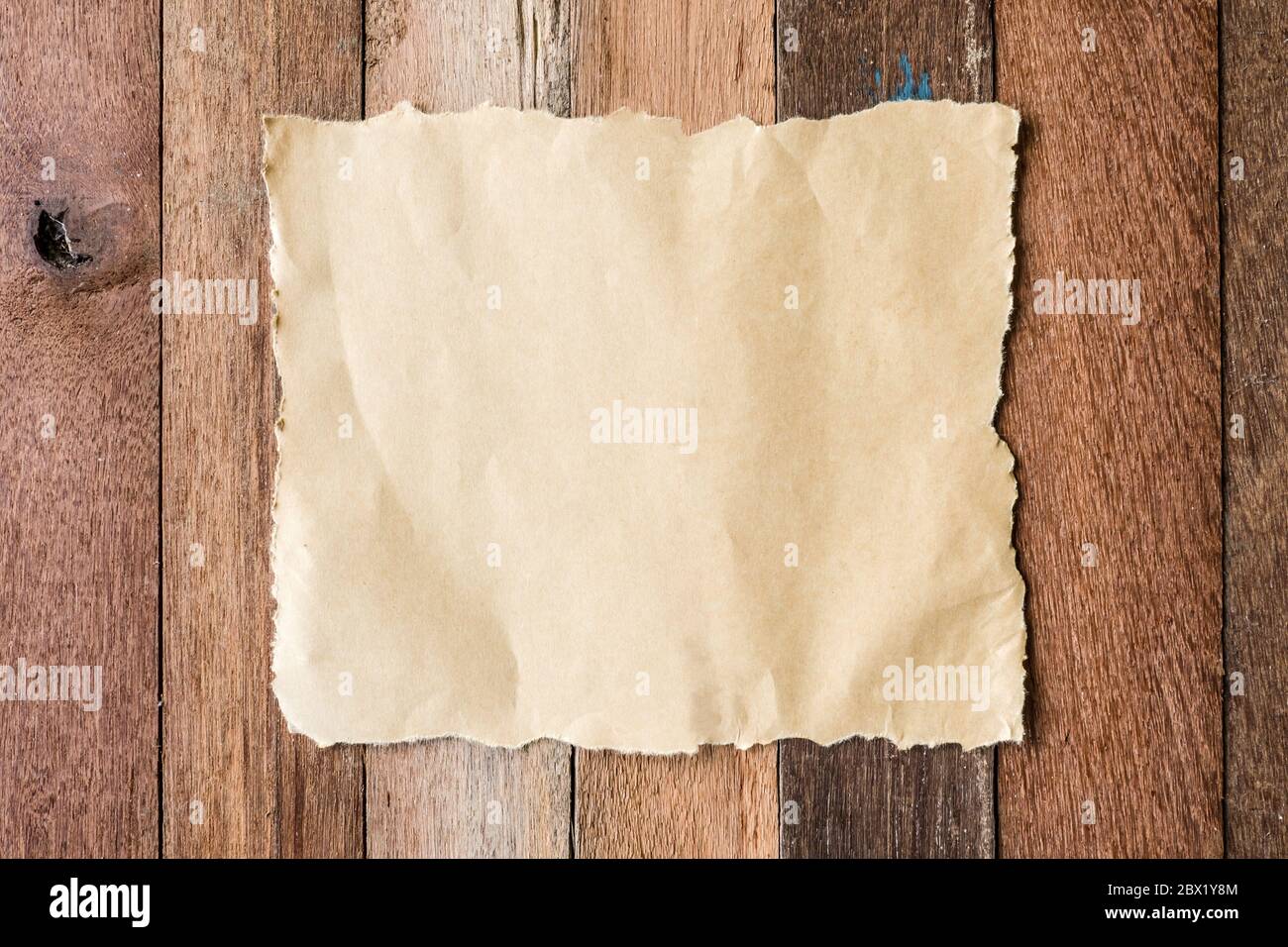 Vista in pianta dello sbozzato carta marrone sul tavolo di legno dello sfondo. Foto Stock