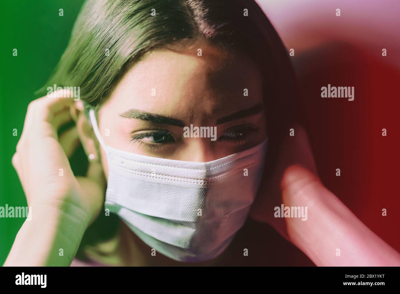 Giovane donna che indossa maschera chirurgica viso contro il virus corona - paura ragazza quarantena per prevenire pandemia diffusione del coronavirus Foto Stock