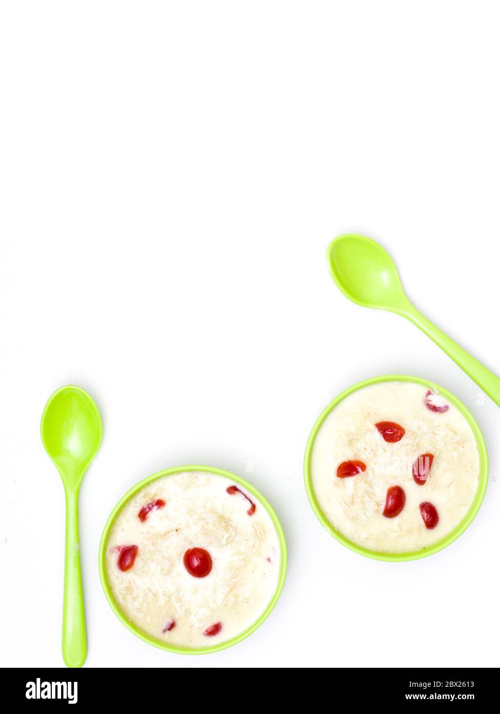 Sewai o kheer consumati in occasione di festival eid o indiani. Servito con condimenti di ciliegia rossa in una ciotola verde. Foto Stock