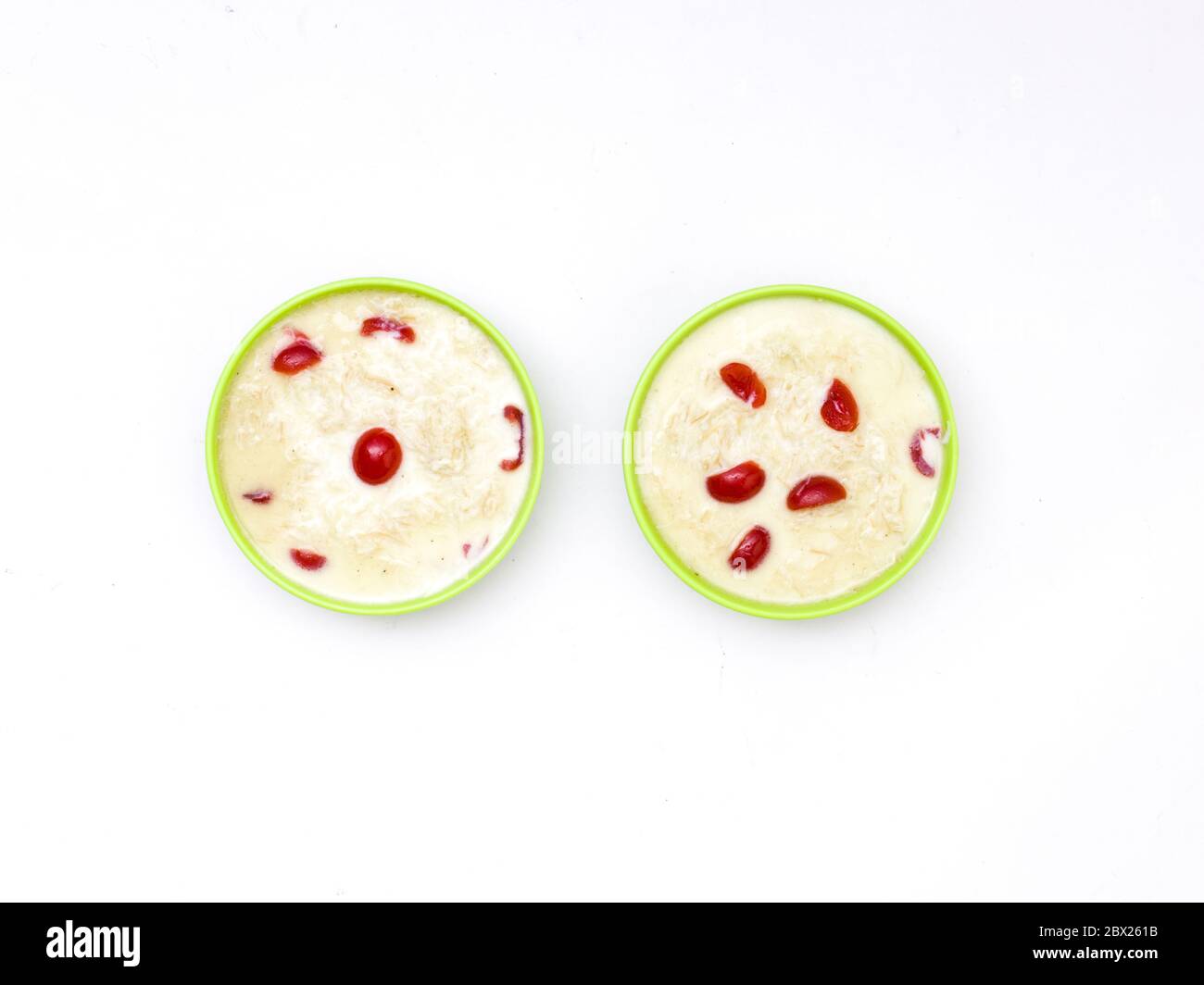 Sewai o kheer consumati in occasione di festival eid o indiani. Servito con condimenti di ciliegia rossa in una ciotola verde. Foto Stock