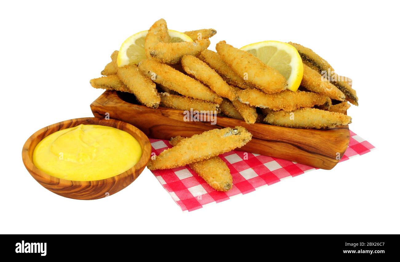 Pane fritto briciolato coperto di pesce bianco con salsa maionese in un piatto di ulivo isolato su sfondo bianco Foto Stock